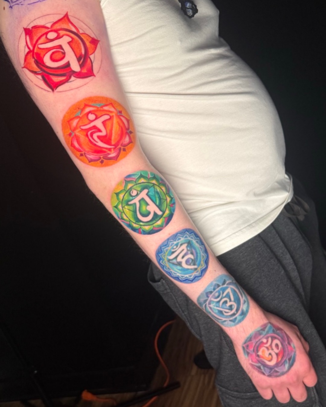 Chakra symbols dotwork tattoo on the forearm by Amy Zager
