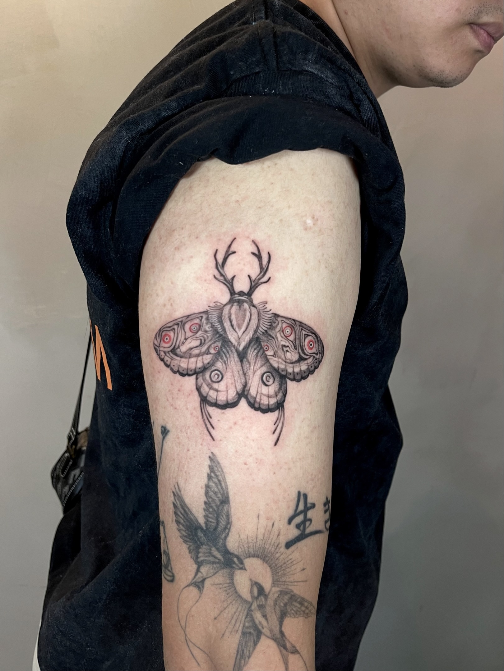 Moth with antlers black and grey tattoo on the upper arm by Arhem Quiambao