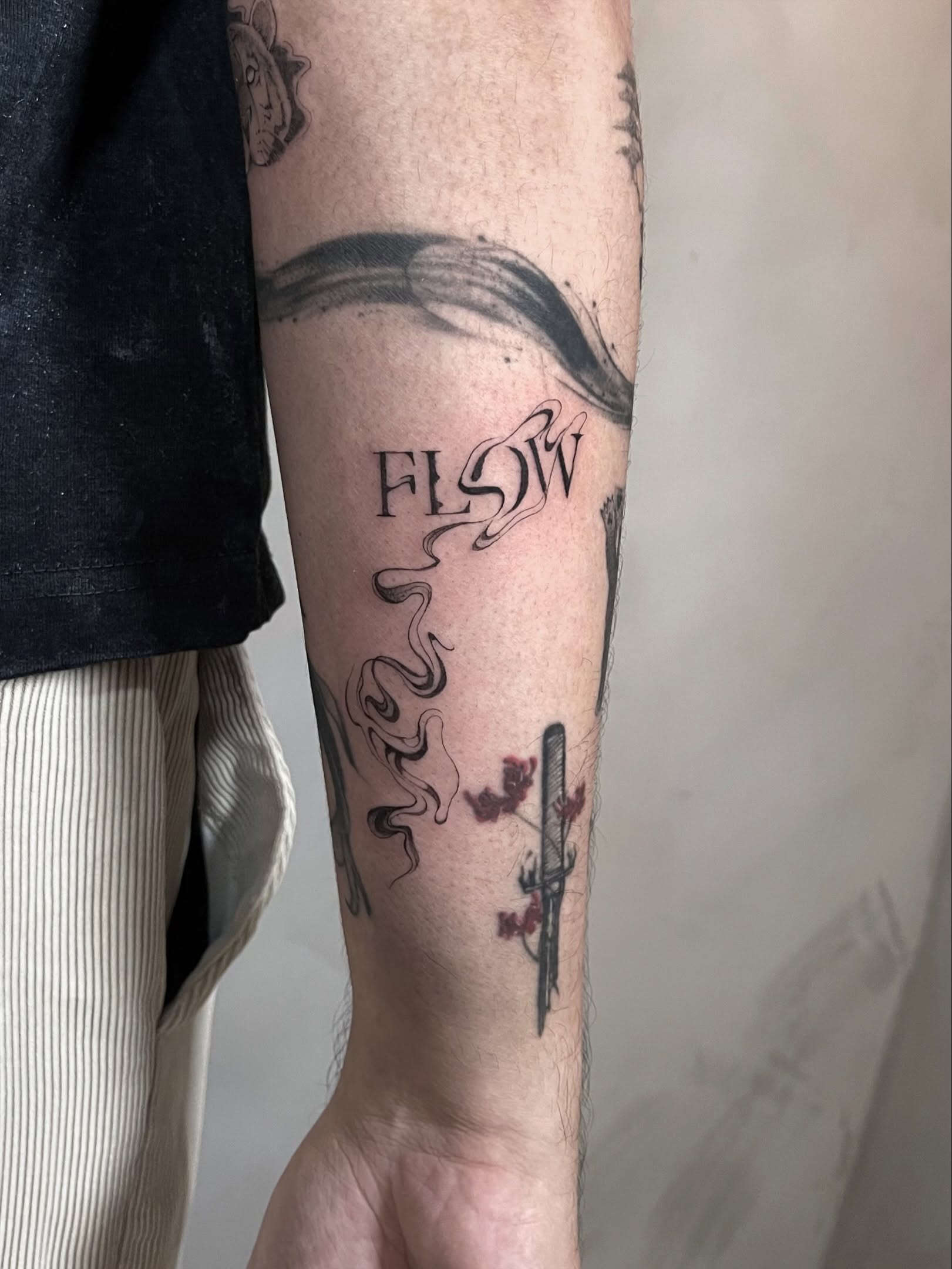 Flow black and grey tattoo on the forearm by Arhem Quiambao