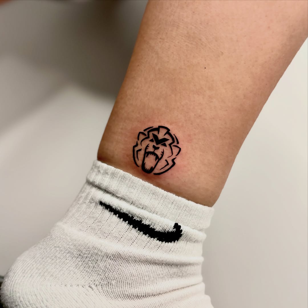 Roaring lion black and grey tattoo on the forearm by Orca