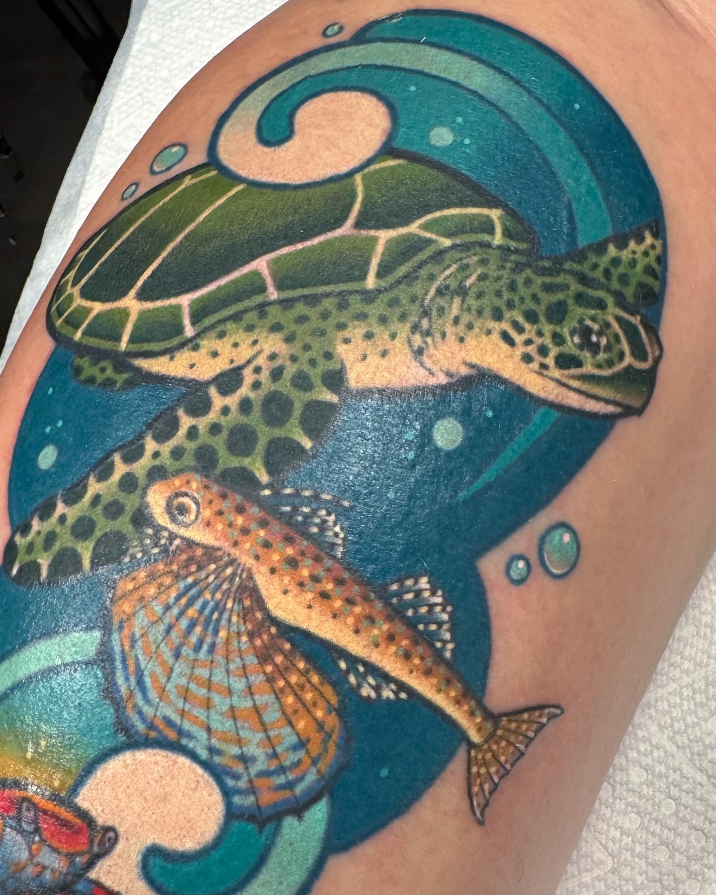 Sea turtle and fish dotwork tattoo on the upper arm by Janine Ramos