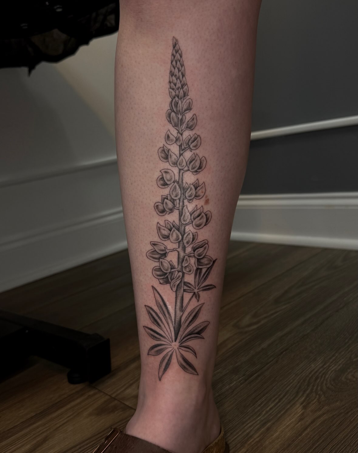 Lupine flower black and grey tattoo on the calf by Kamakana Pankiwska