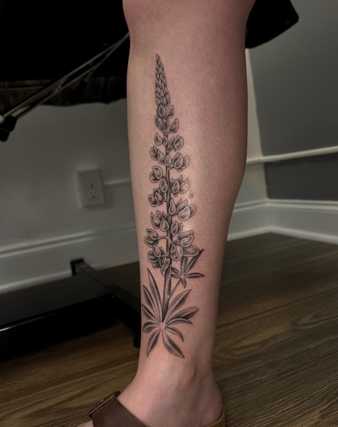 Lupine flower black and grey tattoo on the calf by Kamakana Pankiwska