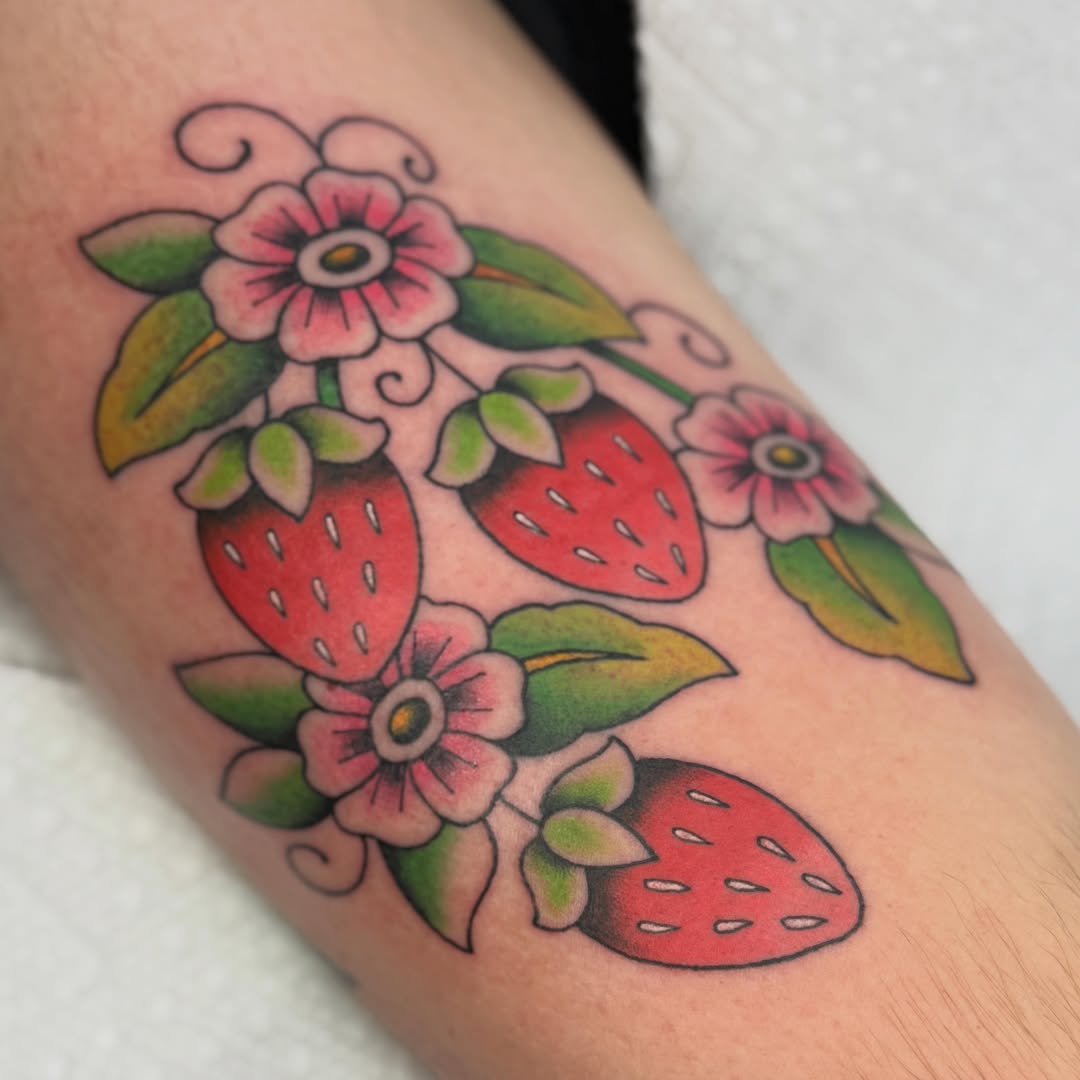 Strawberries and flowers American traditional tattoo on the forearm by chloe jeanel estrada