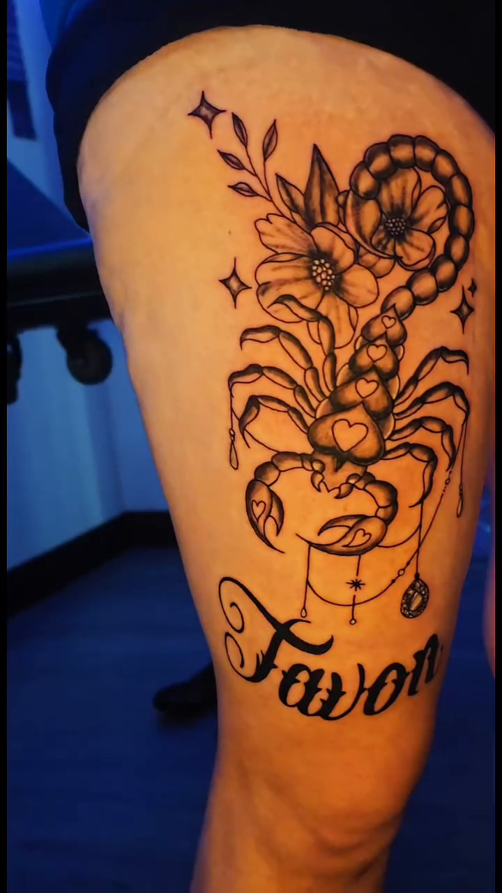 Scorpio with flowers and script fine line tattoo on the thigh by Karley Michelle Moody
