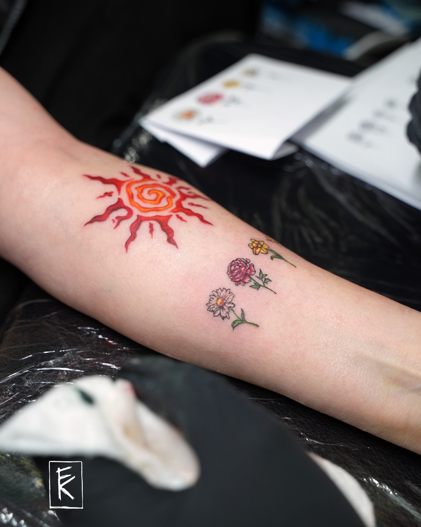 Sun and flowers new school tattoo on the forearm by elizaveta