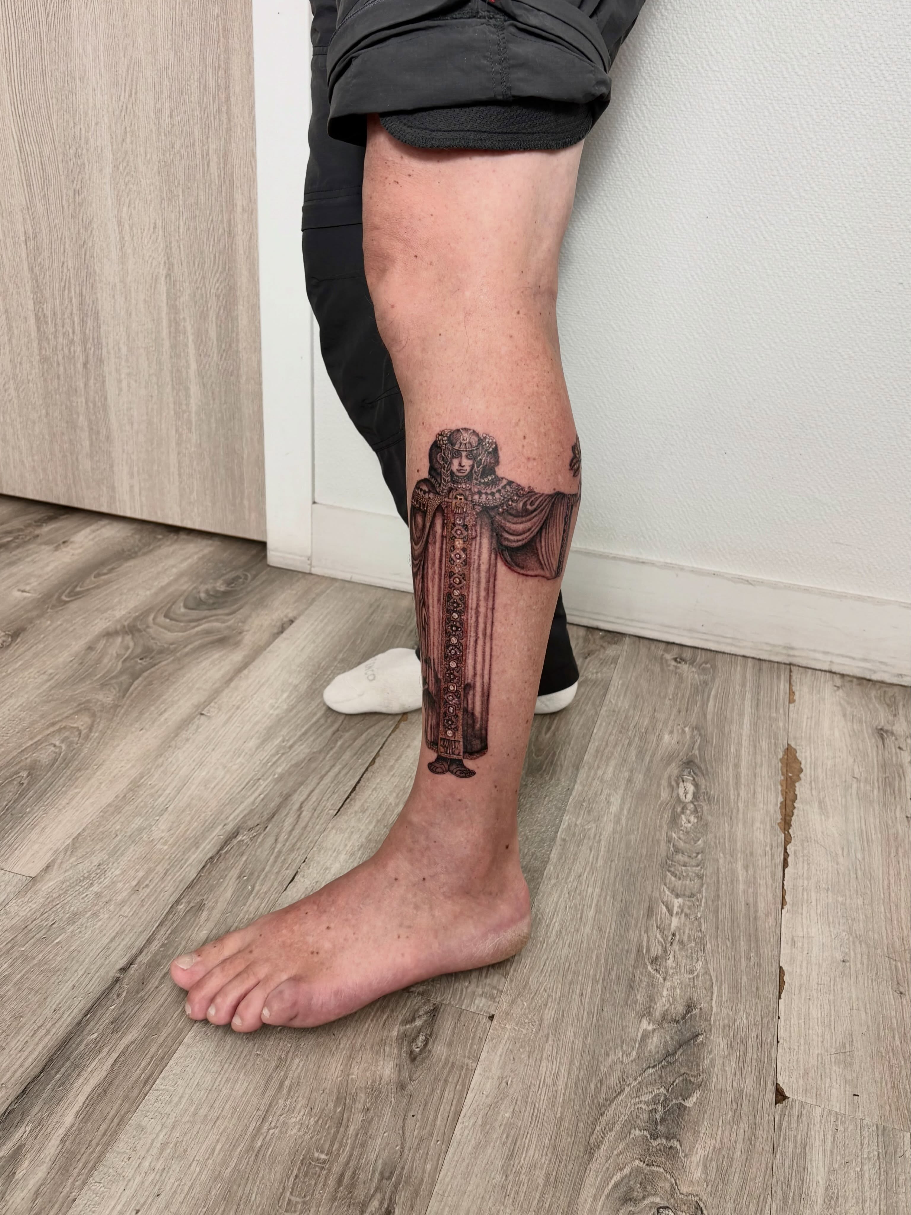 Woman in robe black and grey tattoo on the calf by Deborah