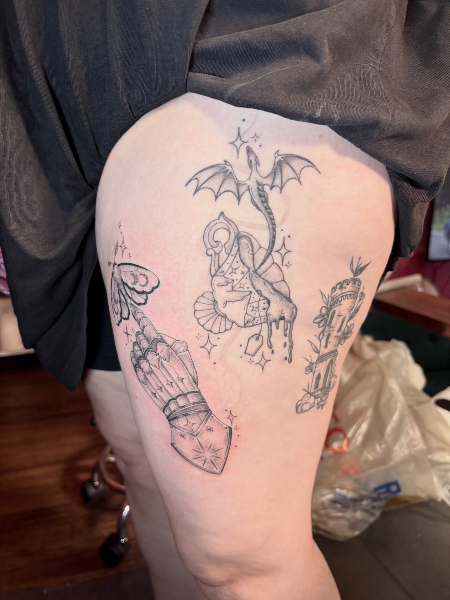 Dragon and shield black and grey tattoo on the thigh by Charlotte Brown, Leeds, England