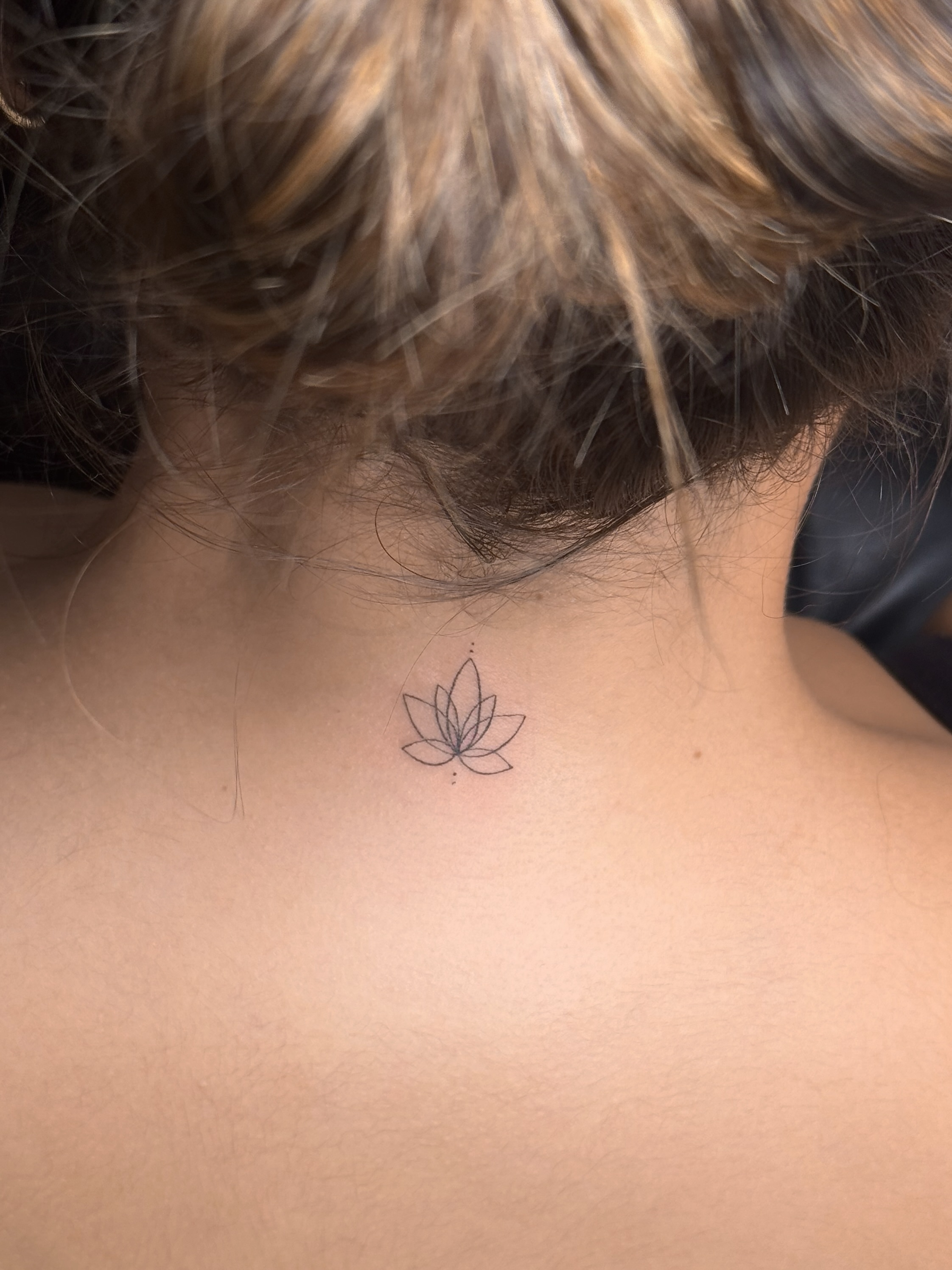 Lotus flower minimalist tattoo on the neck by Victoria