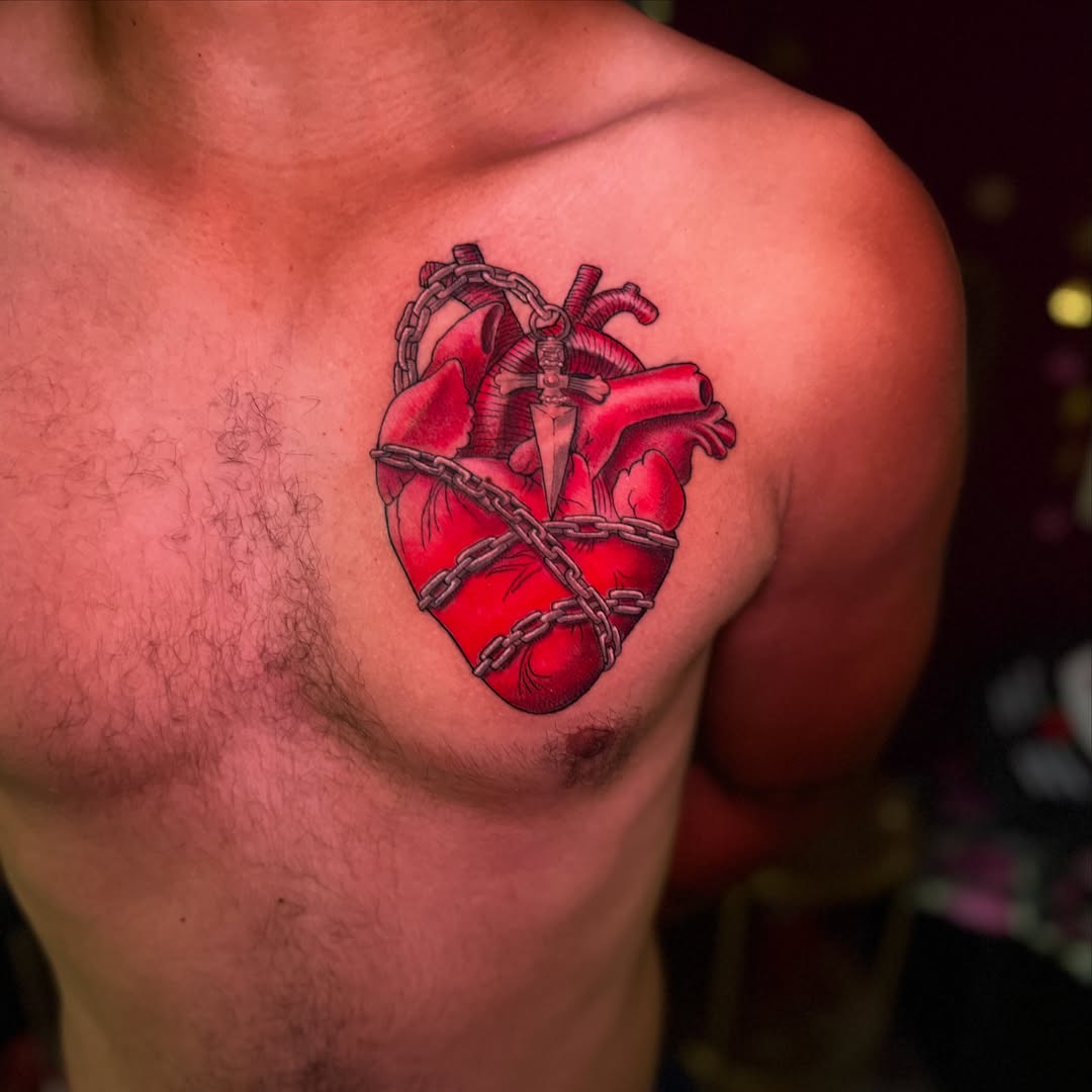 Heart with chains realism tattoo on the chest by Yohana Vargas