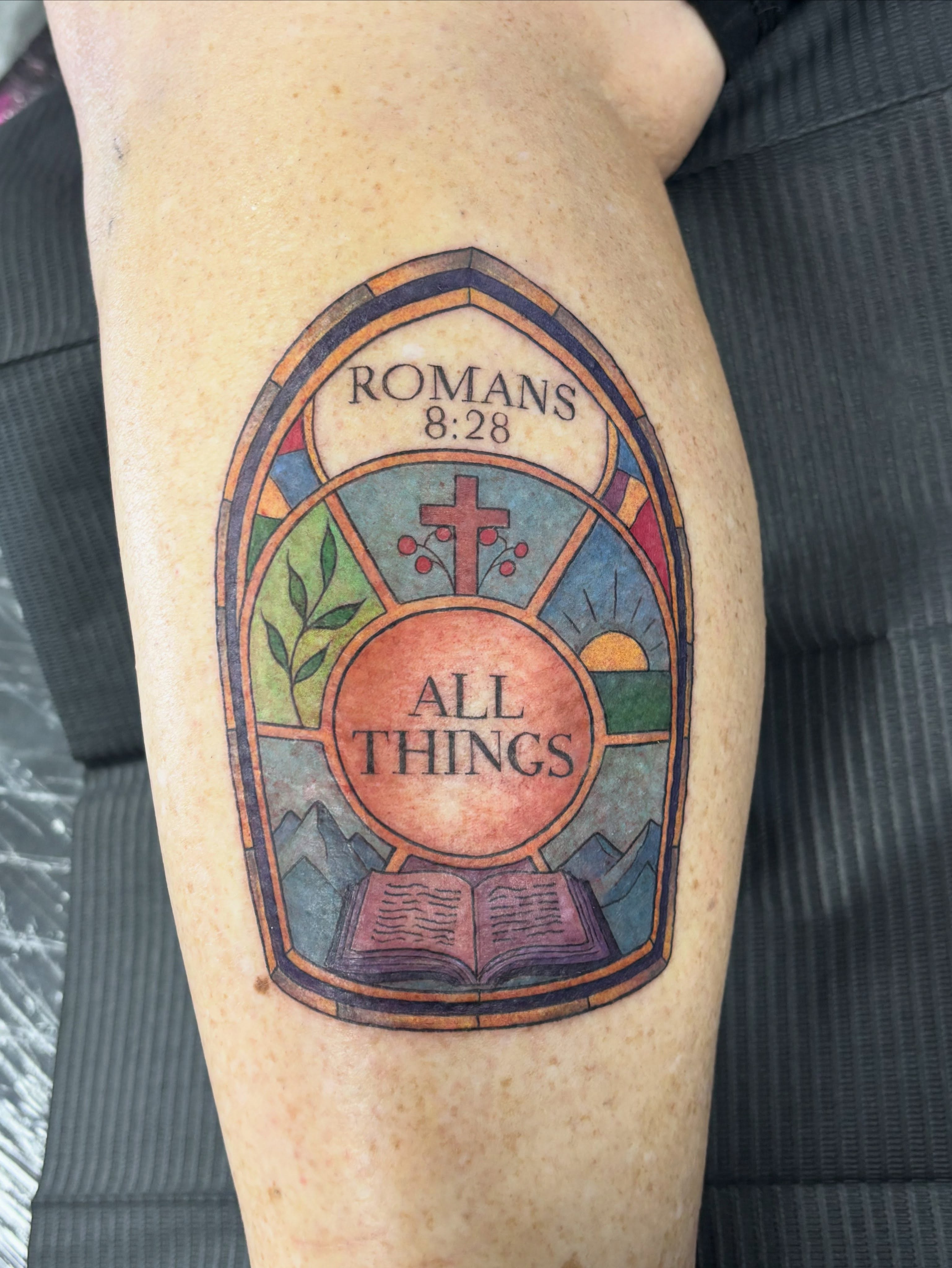 Stained glass window illustrative tattoo on the forearm by Jennifer Flores