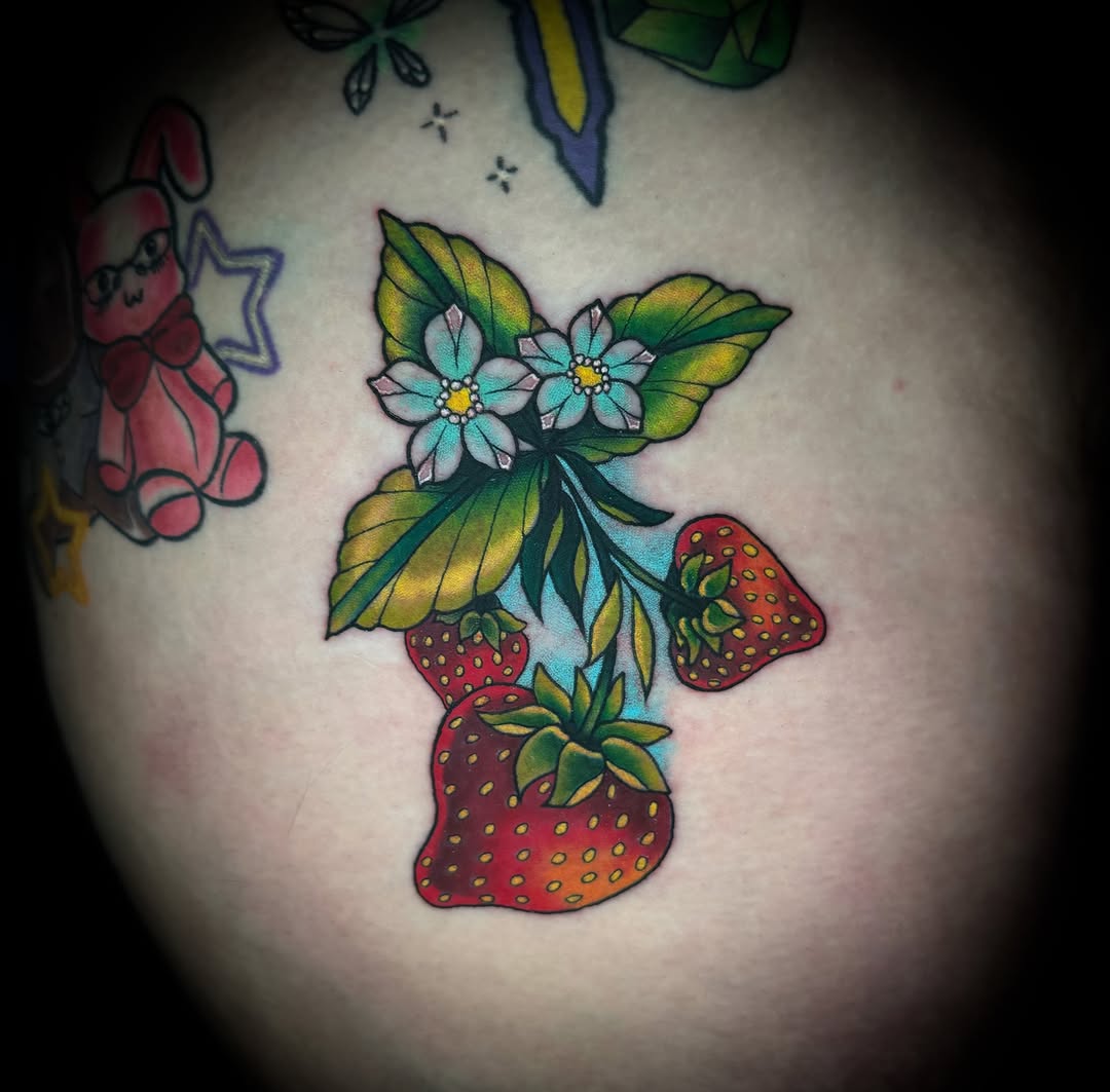 Strawberries and flowers American traditional tattoo on the shoulder by Savannah Duff