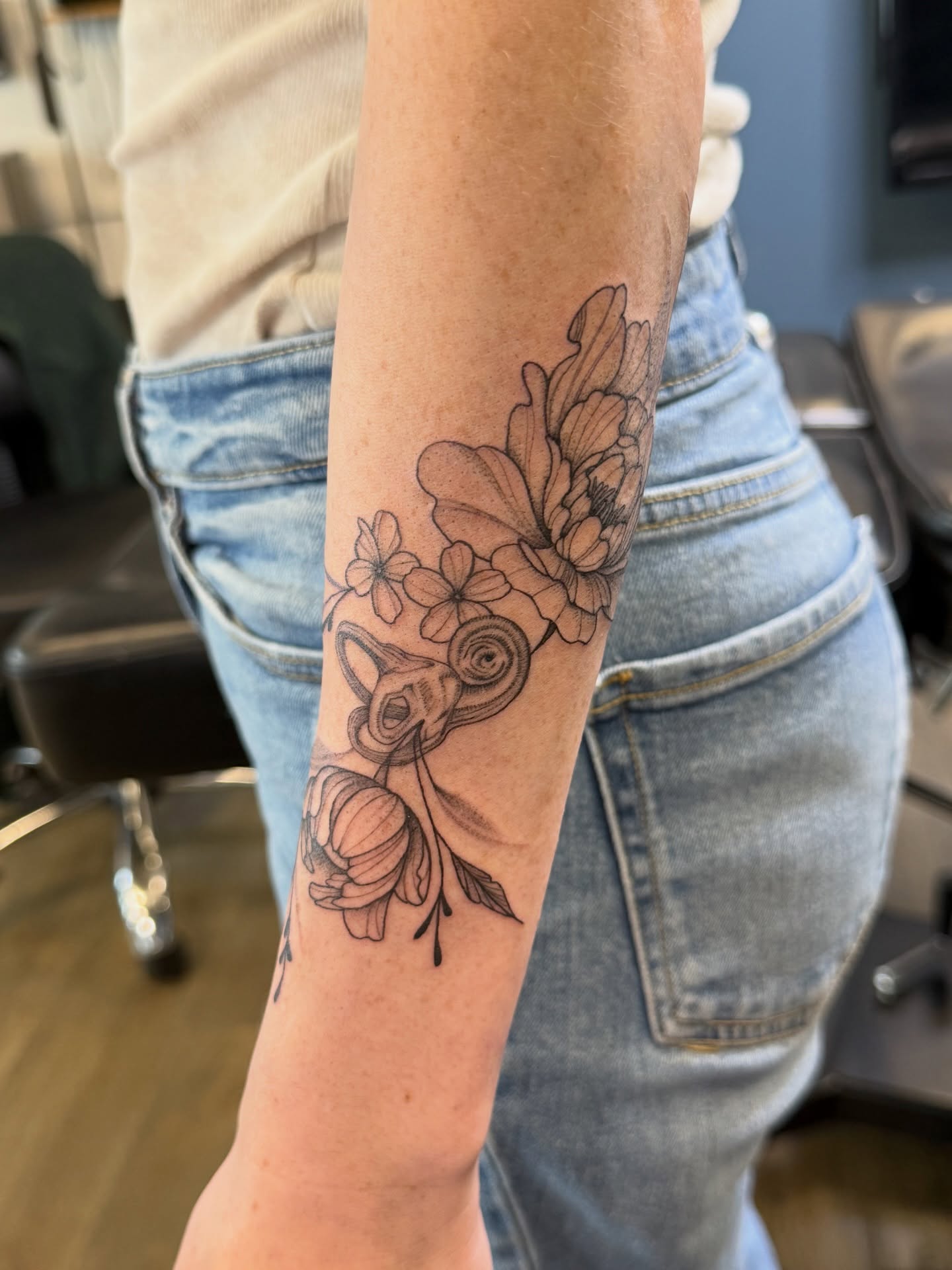 Floral arrangement with ram skull realism tattoo on the forearm by WhoisLaineyTattoos