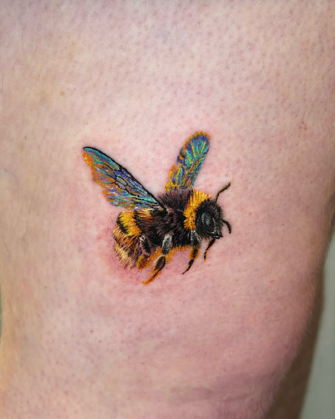 Bumblebee fine line tattoo on the thigh by Yu Chen