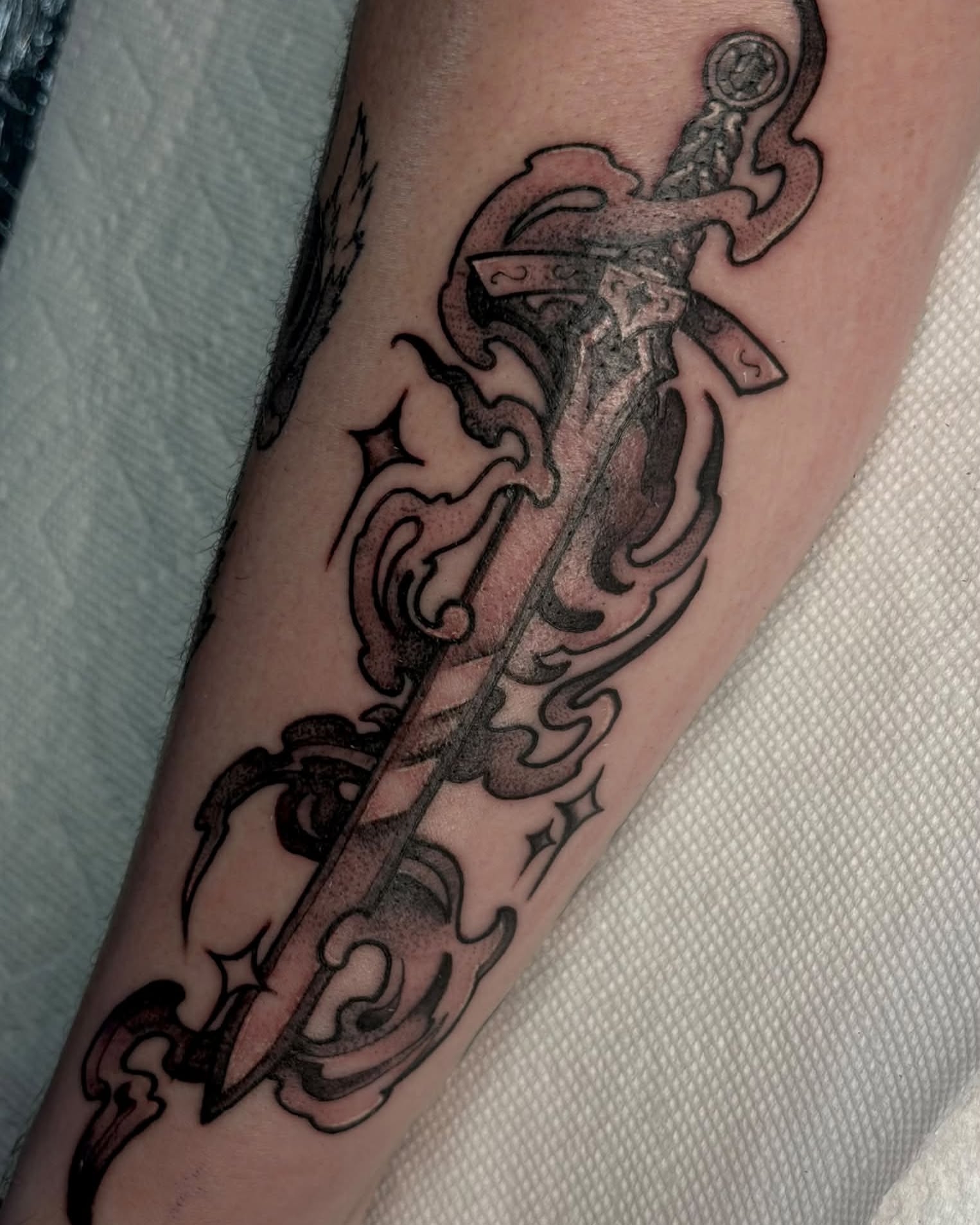 Sword and flame black and grey tattoo on the forearm by Kenneth Prince