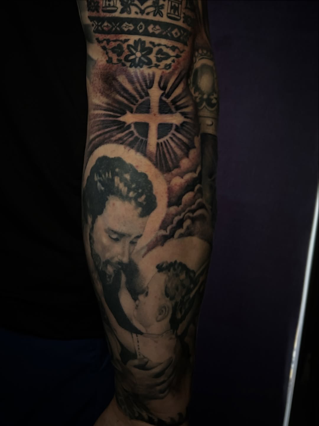 Religious scene with man and child Chicano tattoo on the forearm by Marky