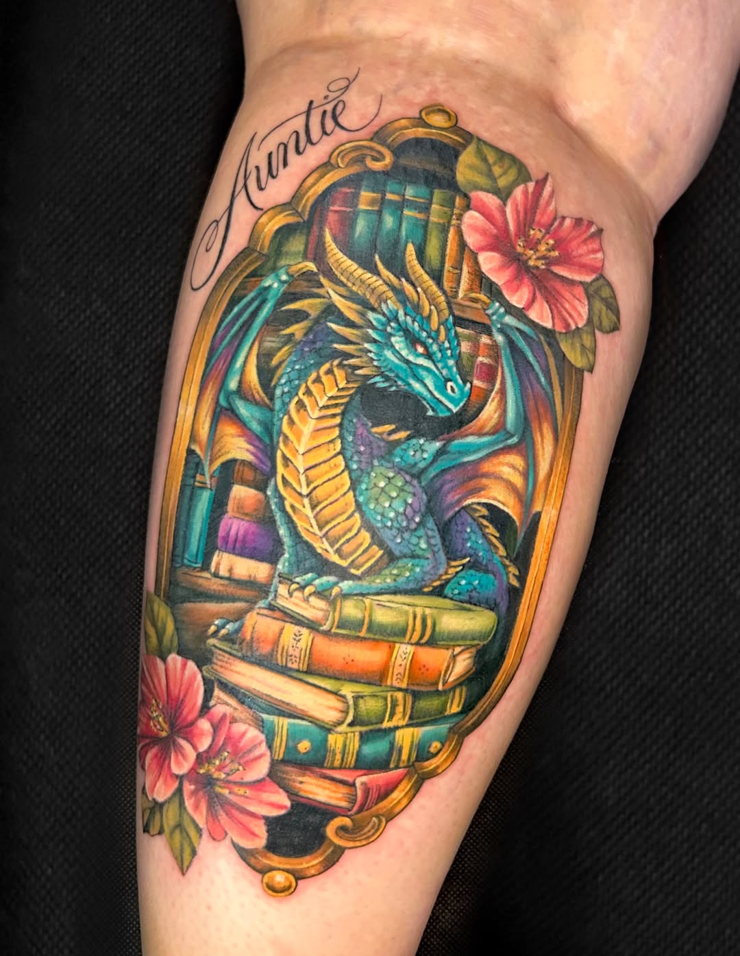 Dragon on books with flowers watercolor tattoo on the forearm by Kim Goff - Special K