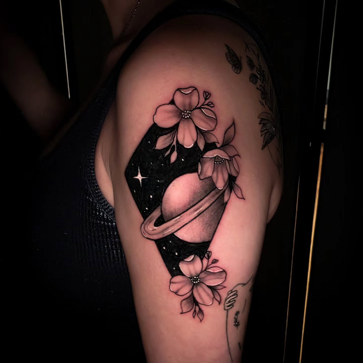 Planetary flower realism tattoo on the upper arm by John Christo Blake