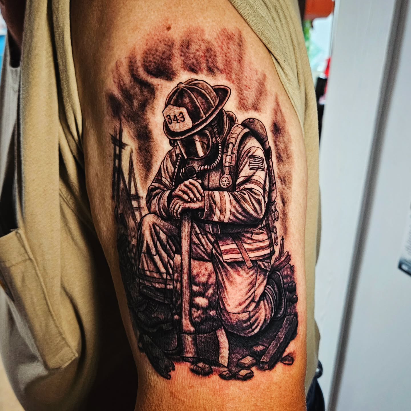 Firefighter kneeling realism tattoo on the forearm by Isaac Morales