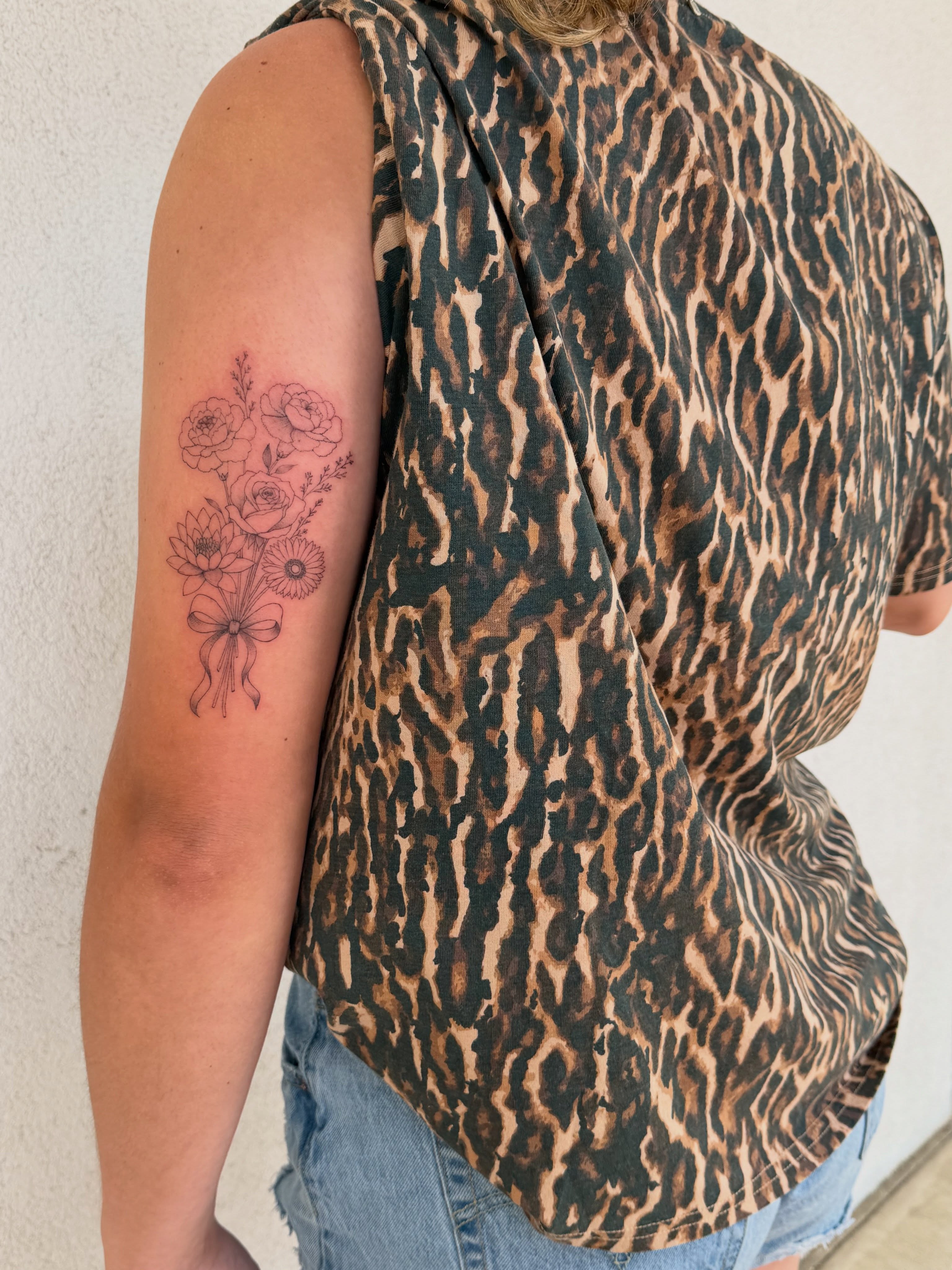 Flower bouquet black and grey tattoo on the upper arm by Jacksyn, Plano, Texas