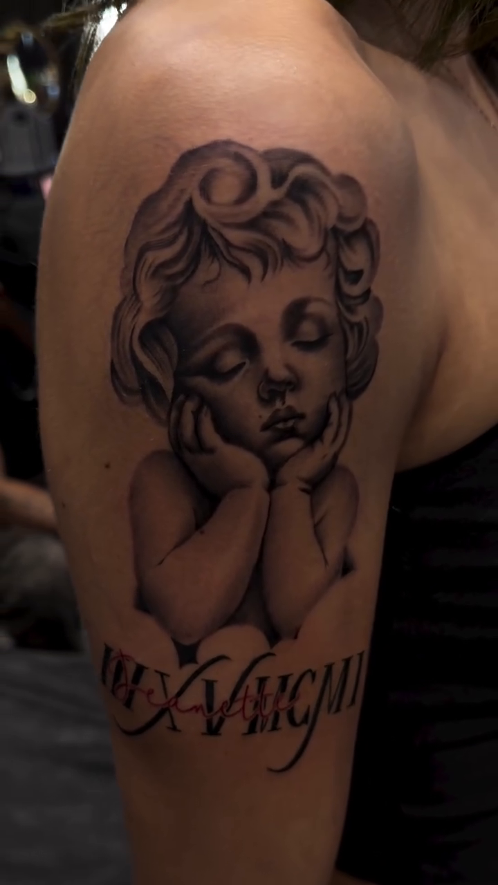 Cherub with Roman numerals realism tattoo on the shoulder by Bernie calderon, Fresno, California