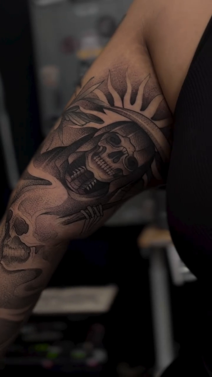 Grim Reaper skull with sun rays realism tattoo on the upper arm by Srey Grace