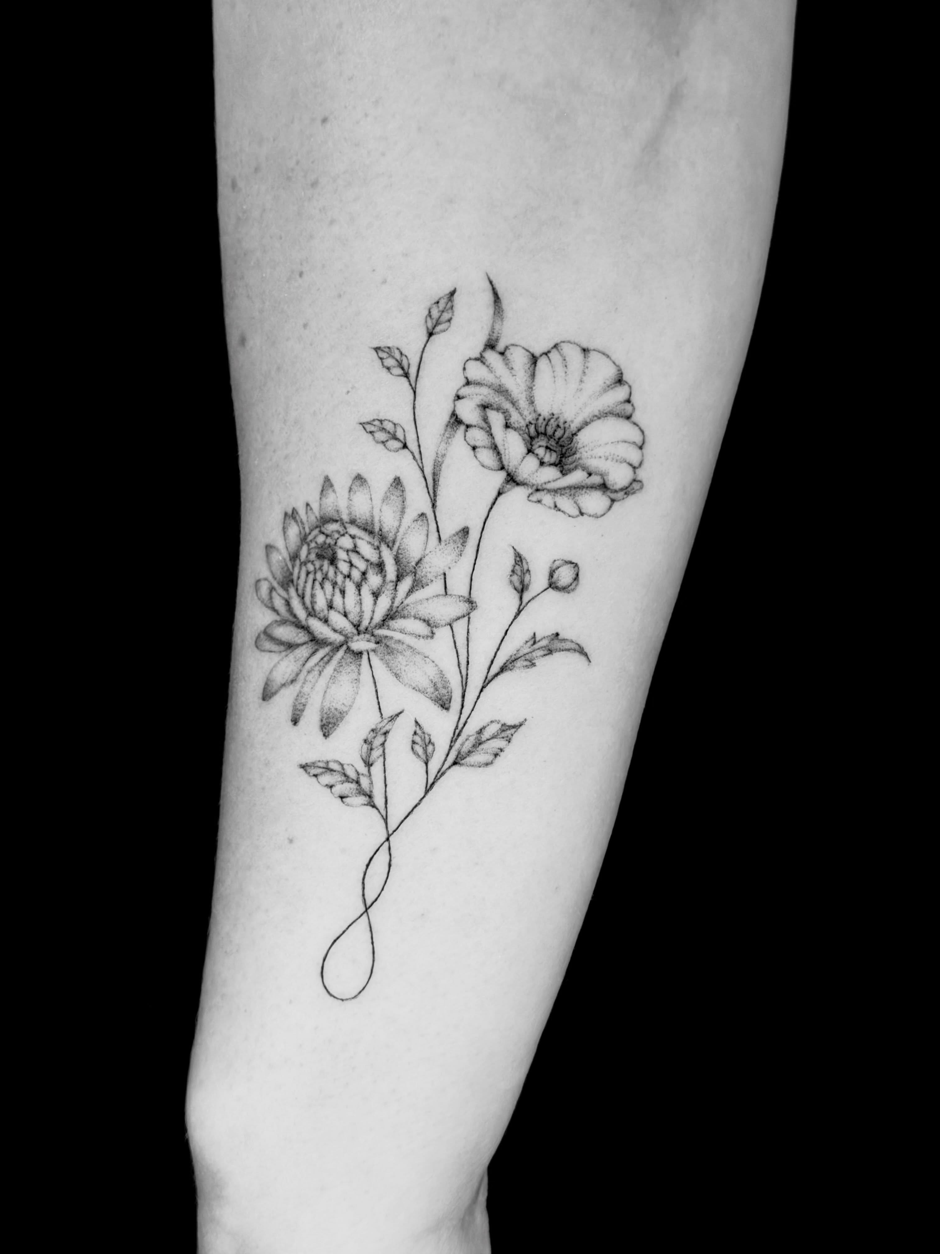 Flowers black and grey tattoo on the forearm by Fine Line Tattoo Artist