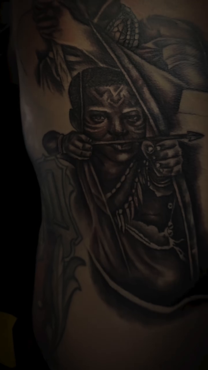 Warrior with mask and bow realism tattoo by Devin Johnson, Forest Park, Georgia