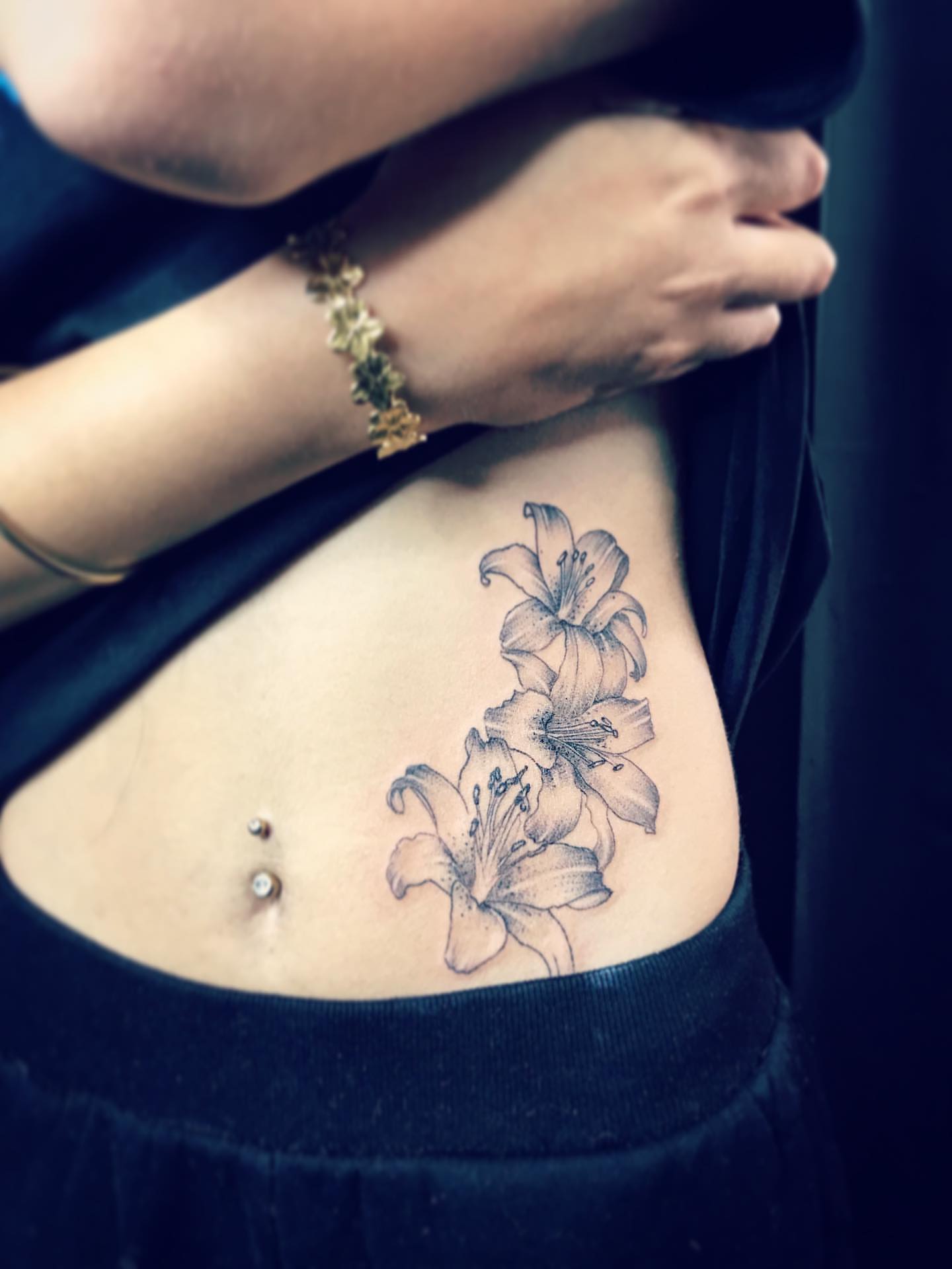 Lilies black and grey tattoo on the torso by Moss Quito Tattoo