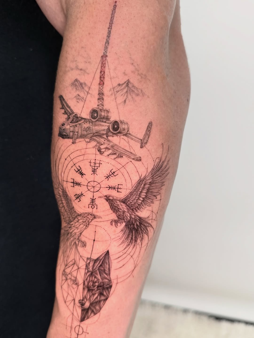 Airplane, raven, wolf, and runic compass realism tattoo on the forearm by Yuri Chloe Ngo Tattoo Artist