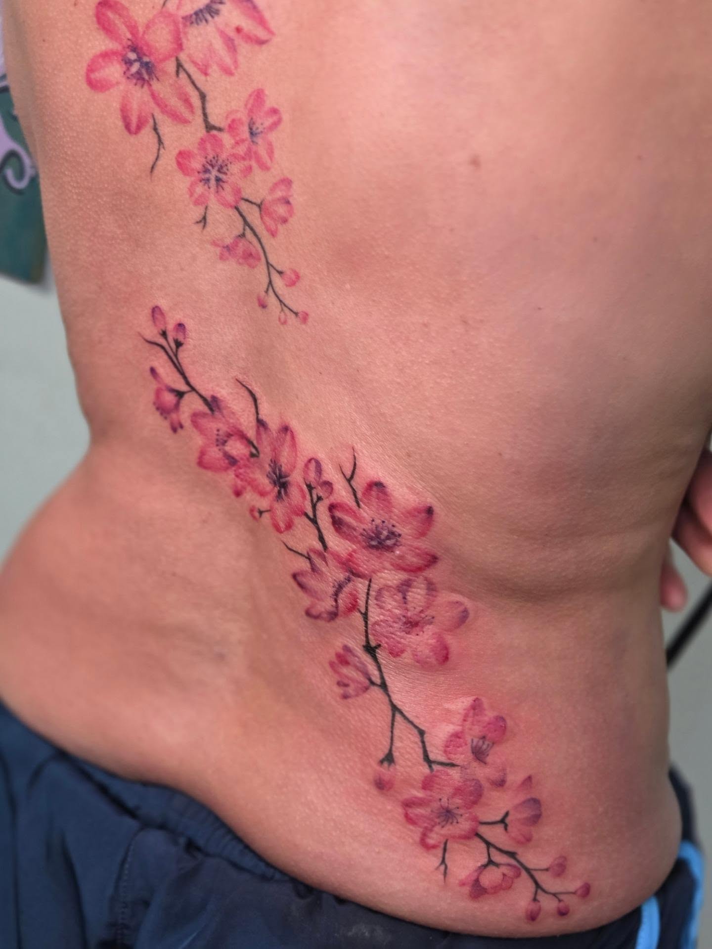 Cherry blossoms watercolor tattoo on the ribs by Yvette Cebreros