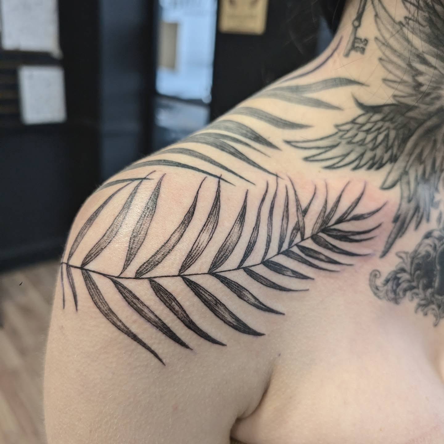 Palm leaf black and grey tattoo on the shoulder by Chad Nuber