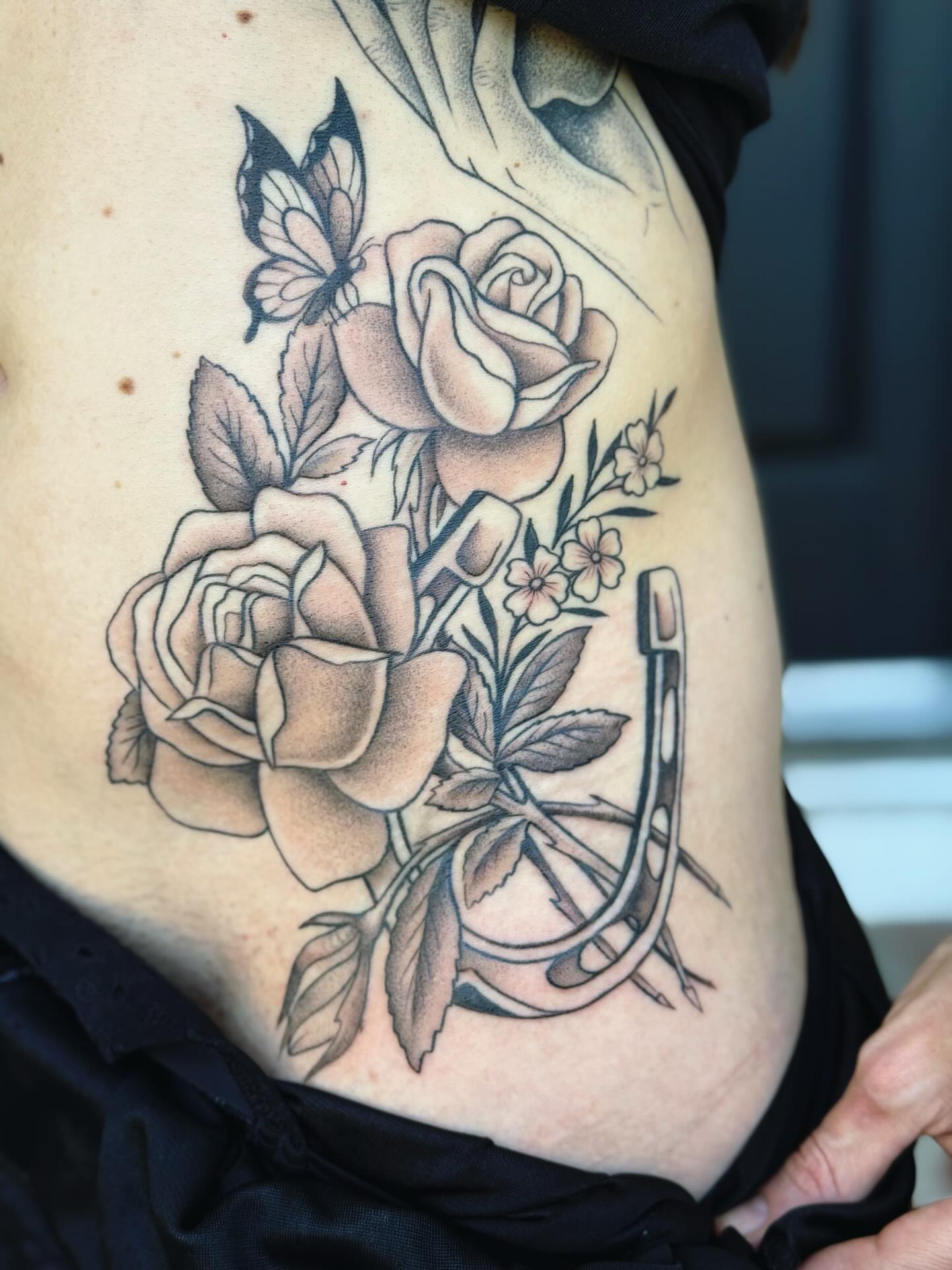 Roses and horseshoe black and grey tattoo on the ribs by π½πππππ π½πππππππ, New Orleans, Louisiana