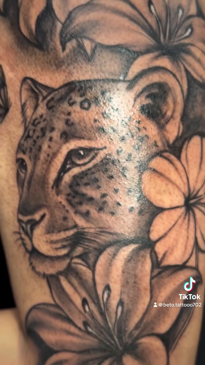 Leopard and lilies tattoo realism tattoo on the upper arm by Betotats