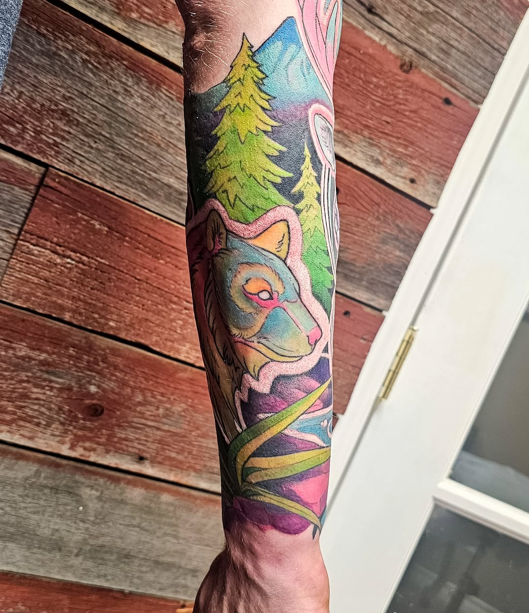 Wolf and forest new school tattoo on the forearm by Savannah