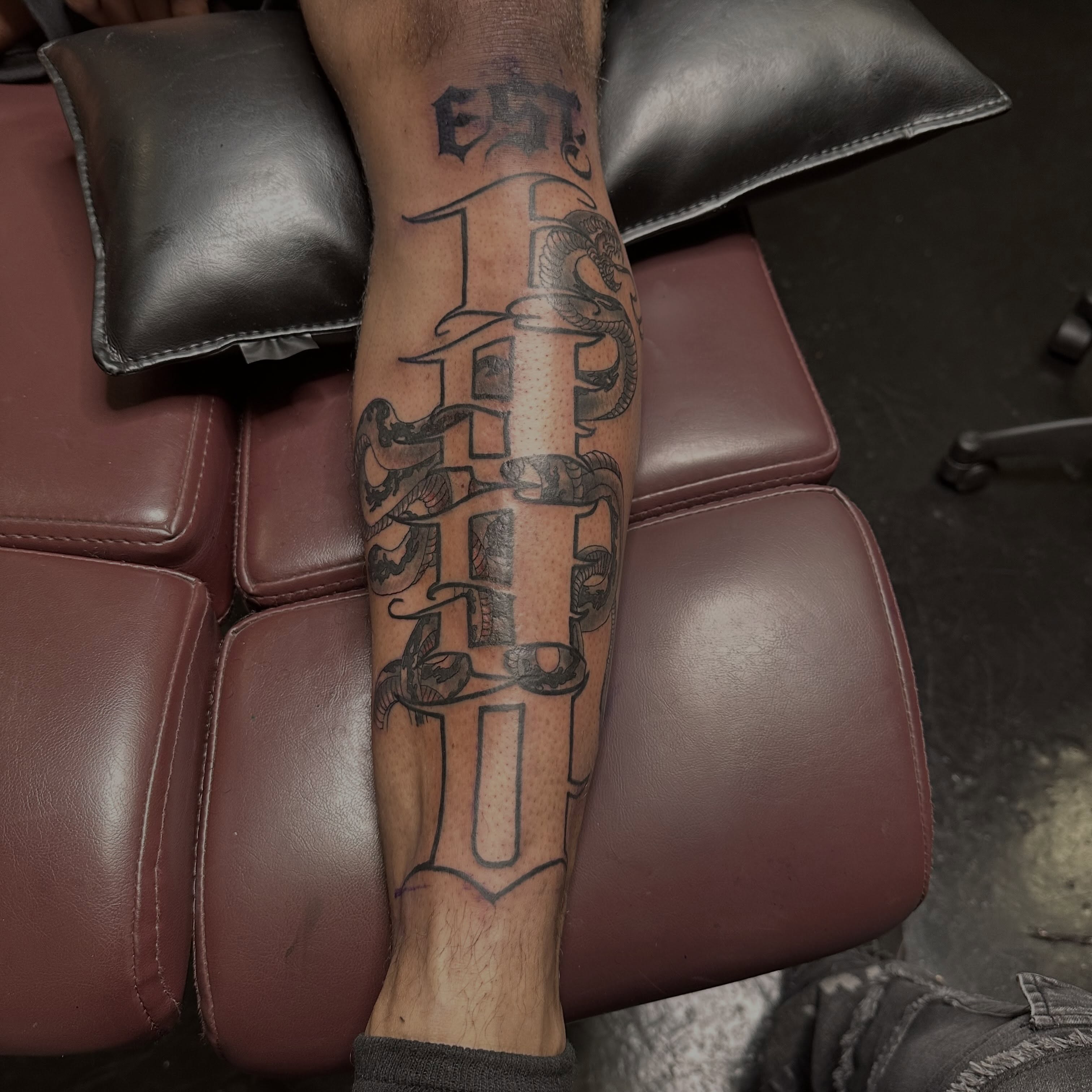 Lettering black and grey tattoo on the forearm by Red (Owner), Brooklyn, New York
