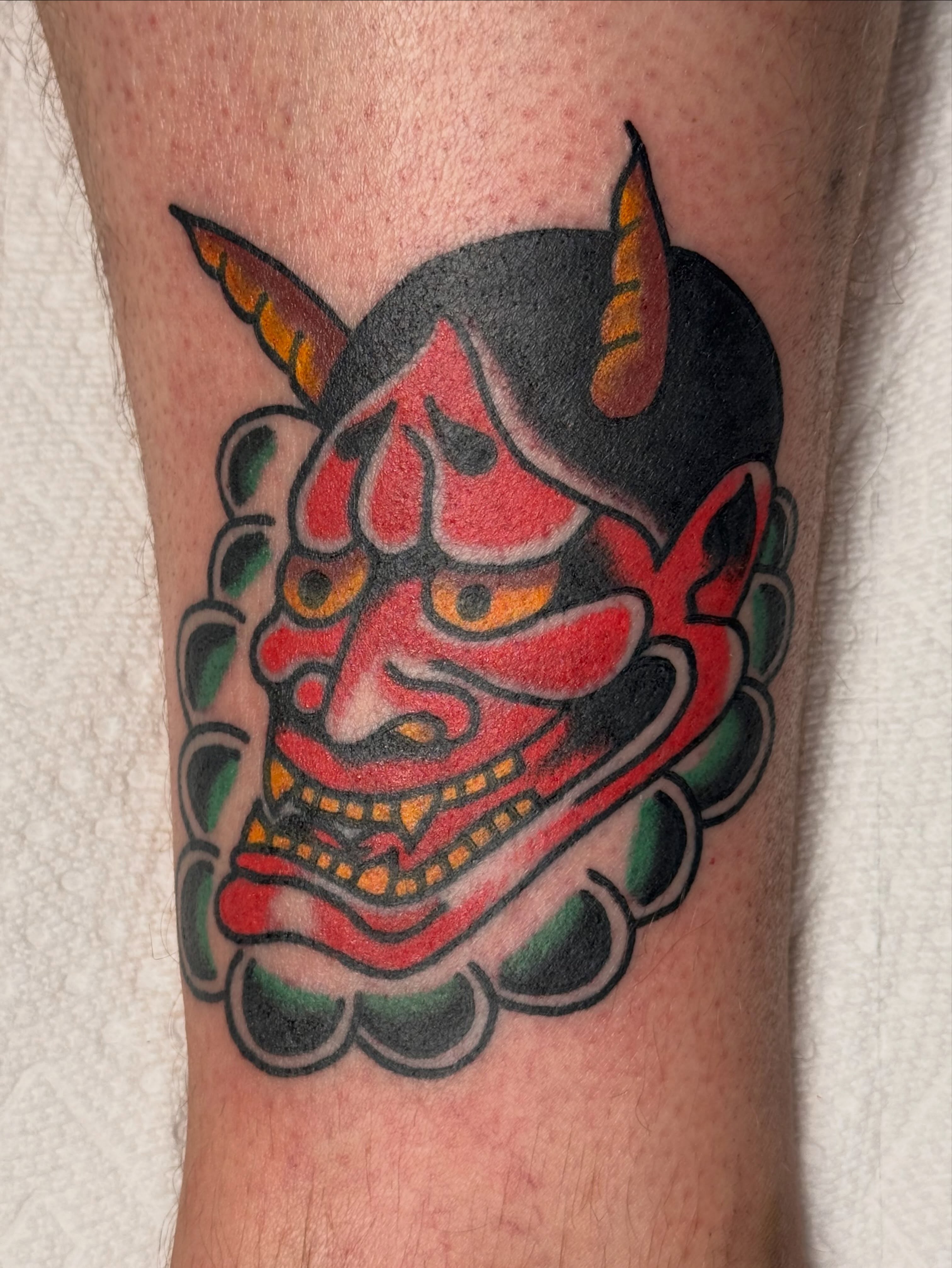 Demon mask American traditional tattoo on the forearm by Zach Lemieux