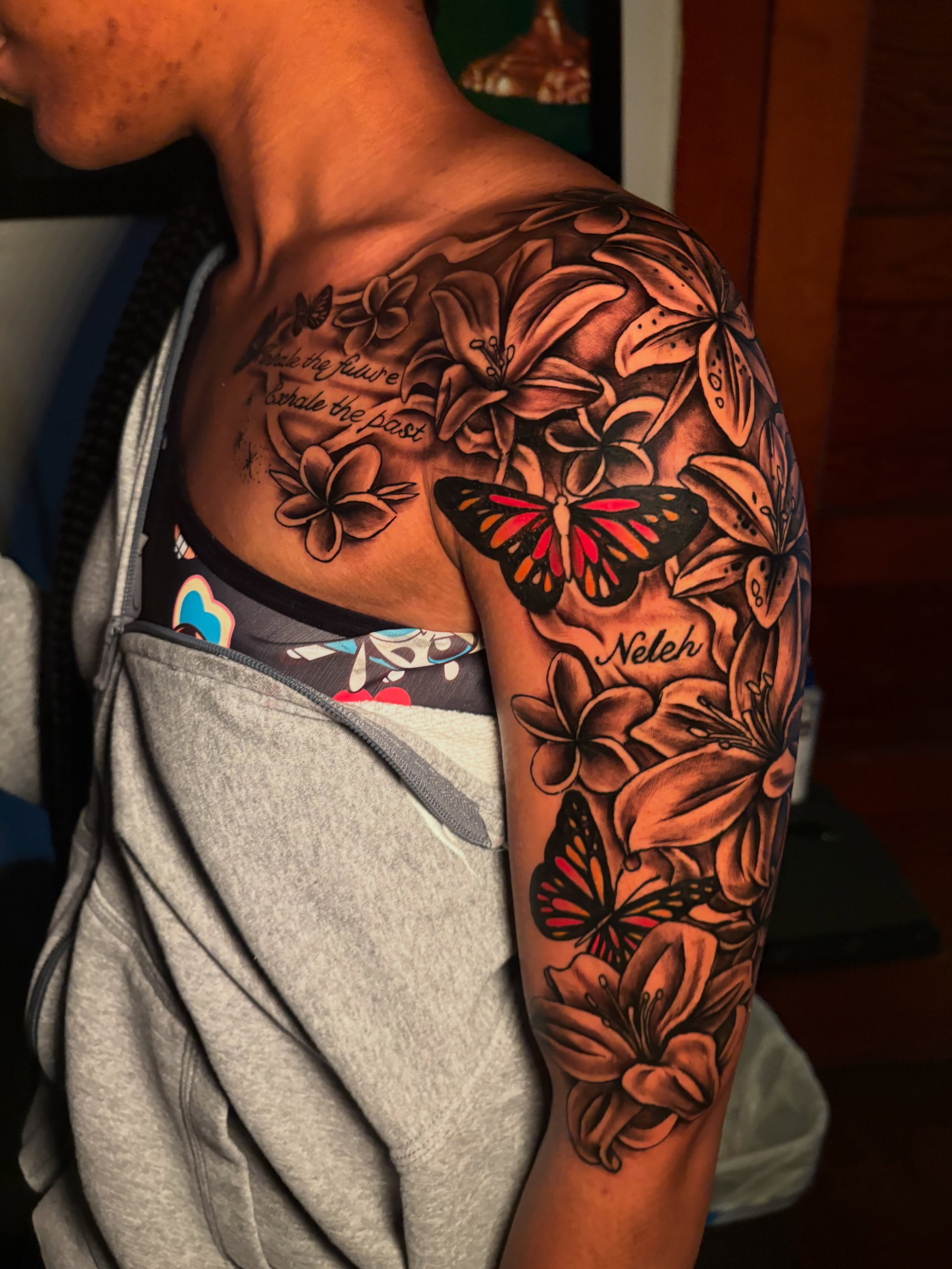 Butterflies and flowers realism tattoo on the upper arm by Maleek Inkz