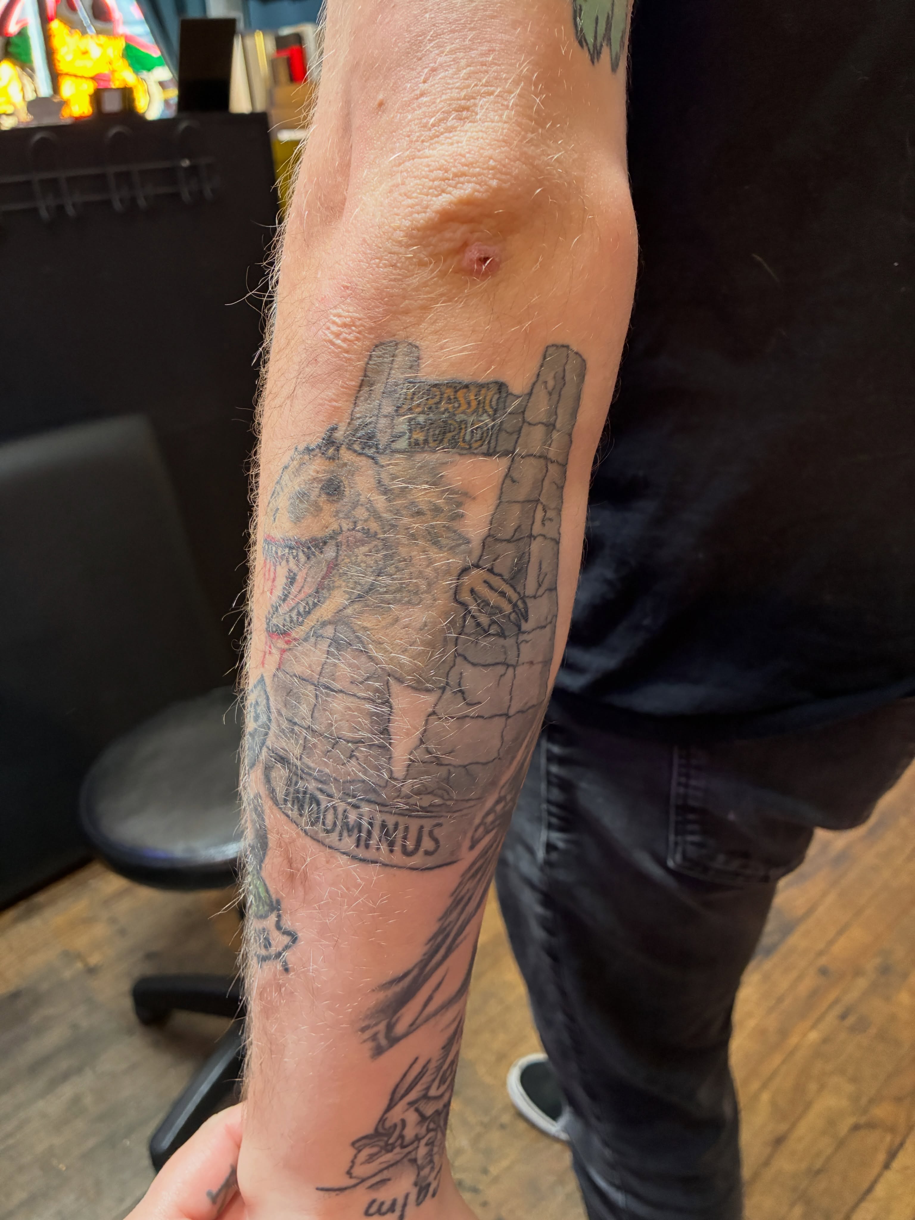 Dinosaur black and grey tattoo on the forearm by Seattle Tattoo Artist