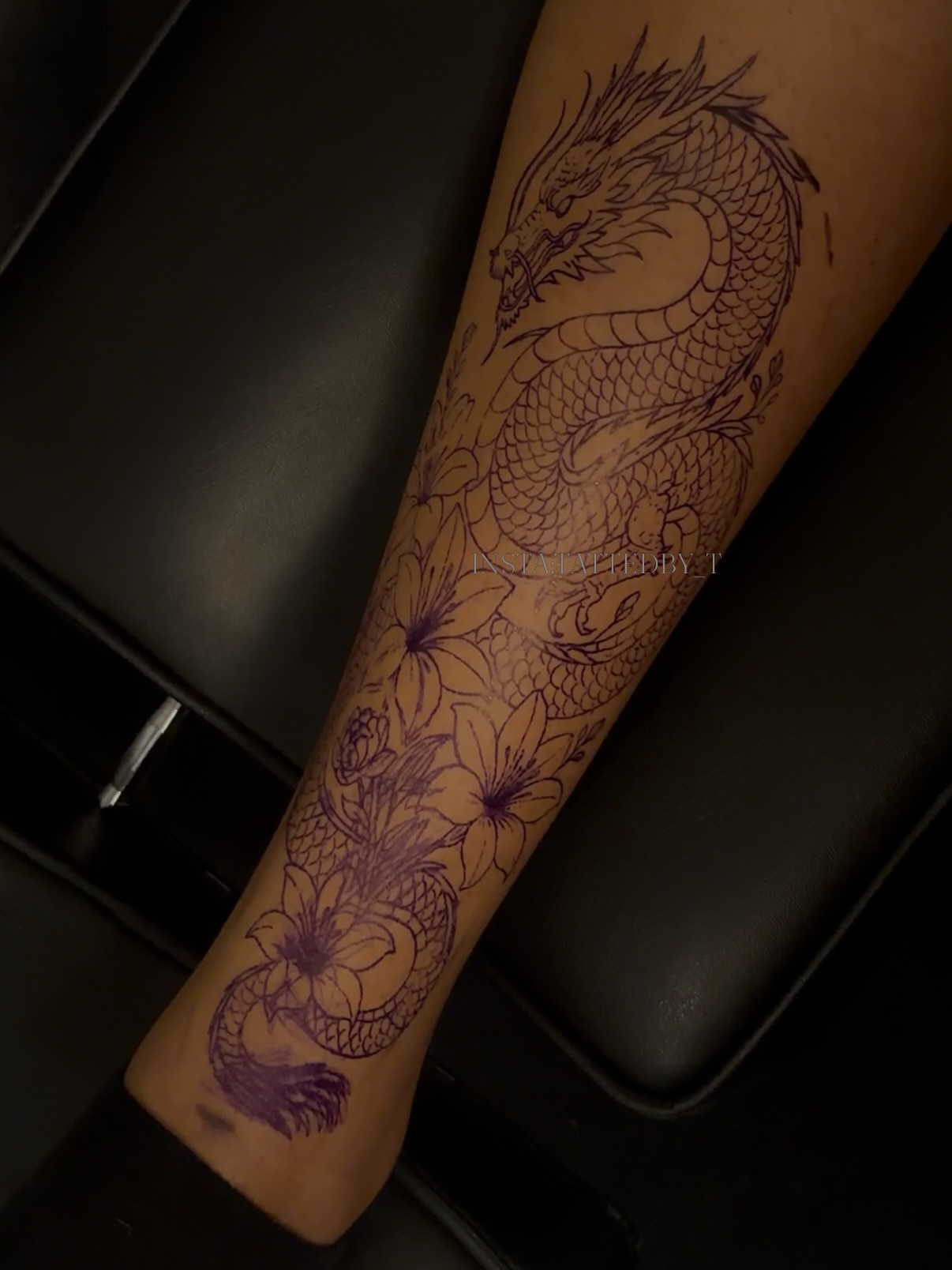 Dragon and flowers black and grey tattoo on the forearm by Female Cleveland Tat Artist ๐