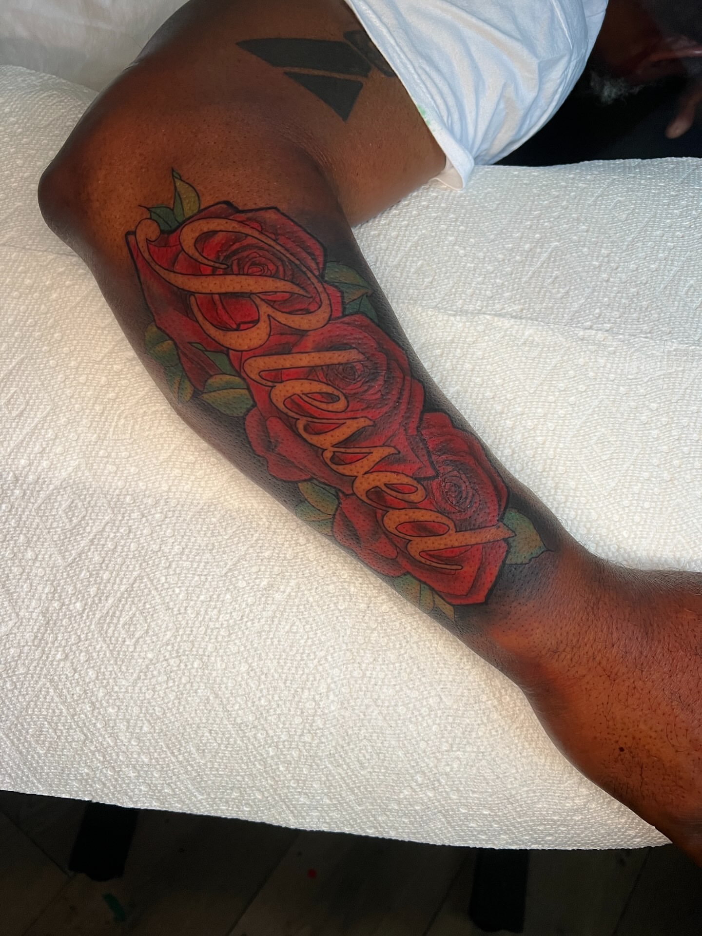 Roses and cursive text realism tattoo on the forearm by Justx4rt