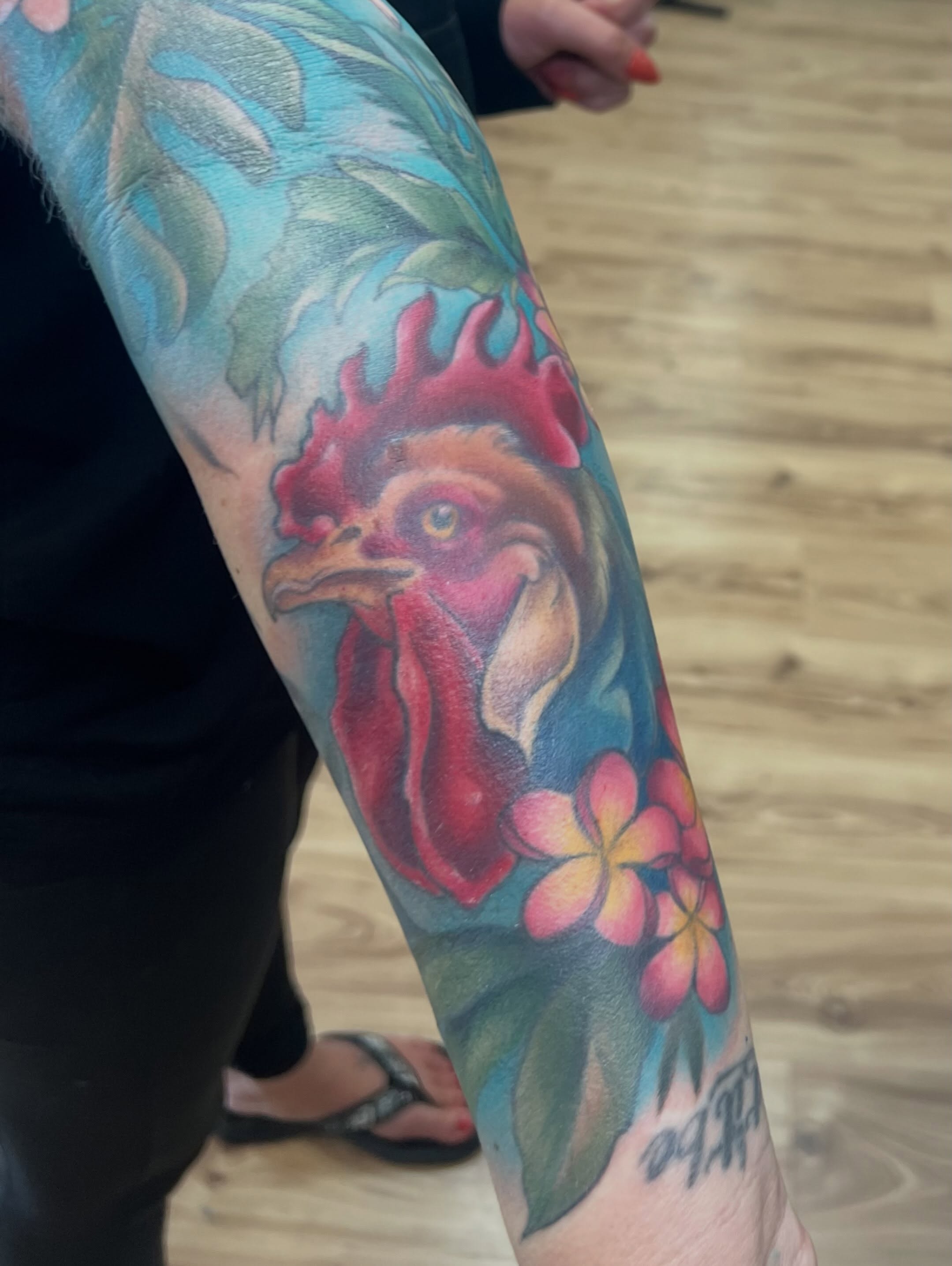 Rooster and flowers realism tattoo on the forearm by Bailey Goodwin, Ankeny, Iowa