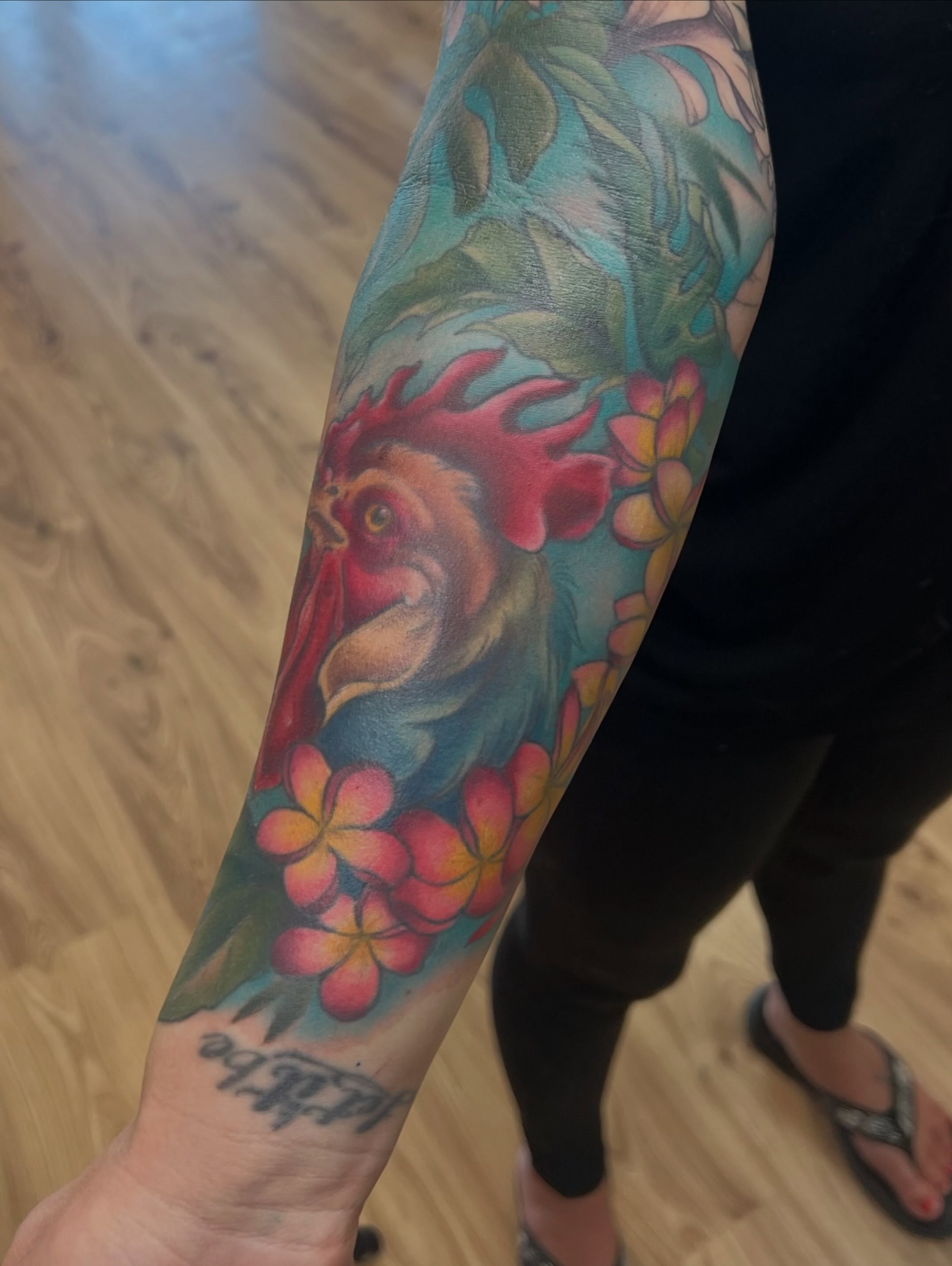 Rooster and flowers new school tattoo on the forearm by Bailey Goodwin, Ankeny, Iowa