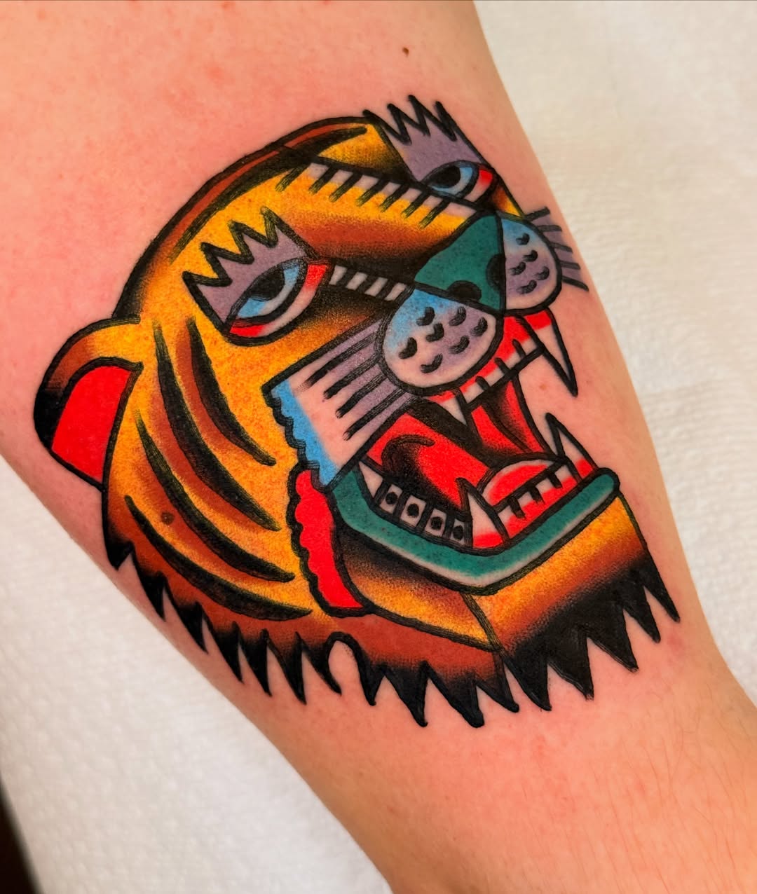 Tiger American traditional tattoo on the forearm by {{Theo Glanton}}
