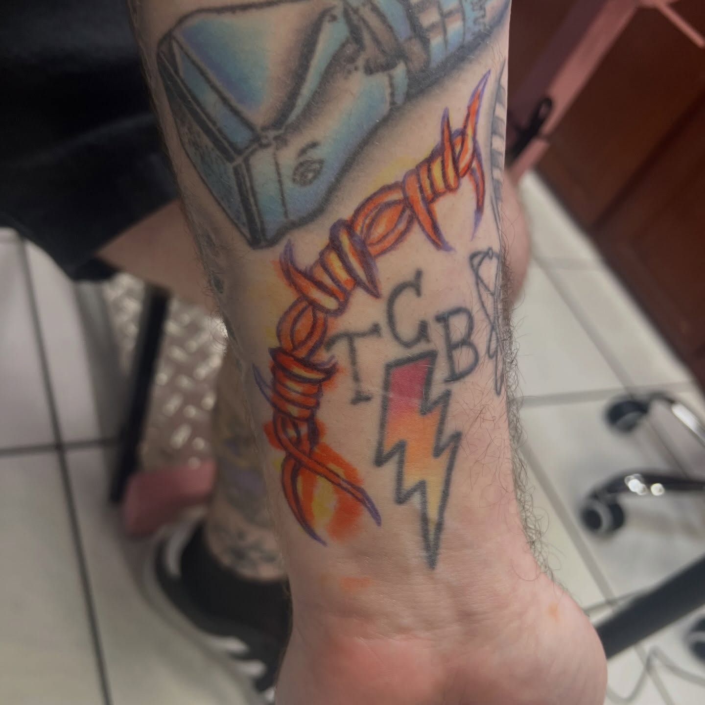 TCB lightning bolt new school tattoo on the forearm by Tomfoolery