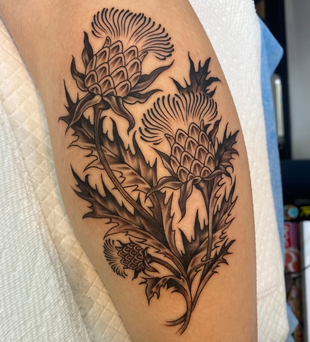 Thistle black and grey tattoo on the thigh by Vivian HavaTattoo, Richmond, Virginia