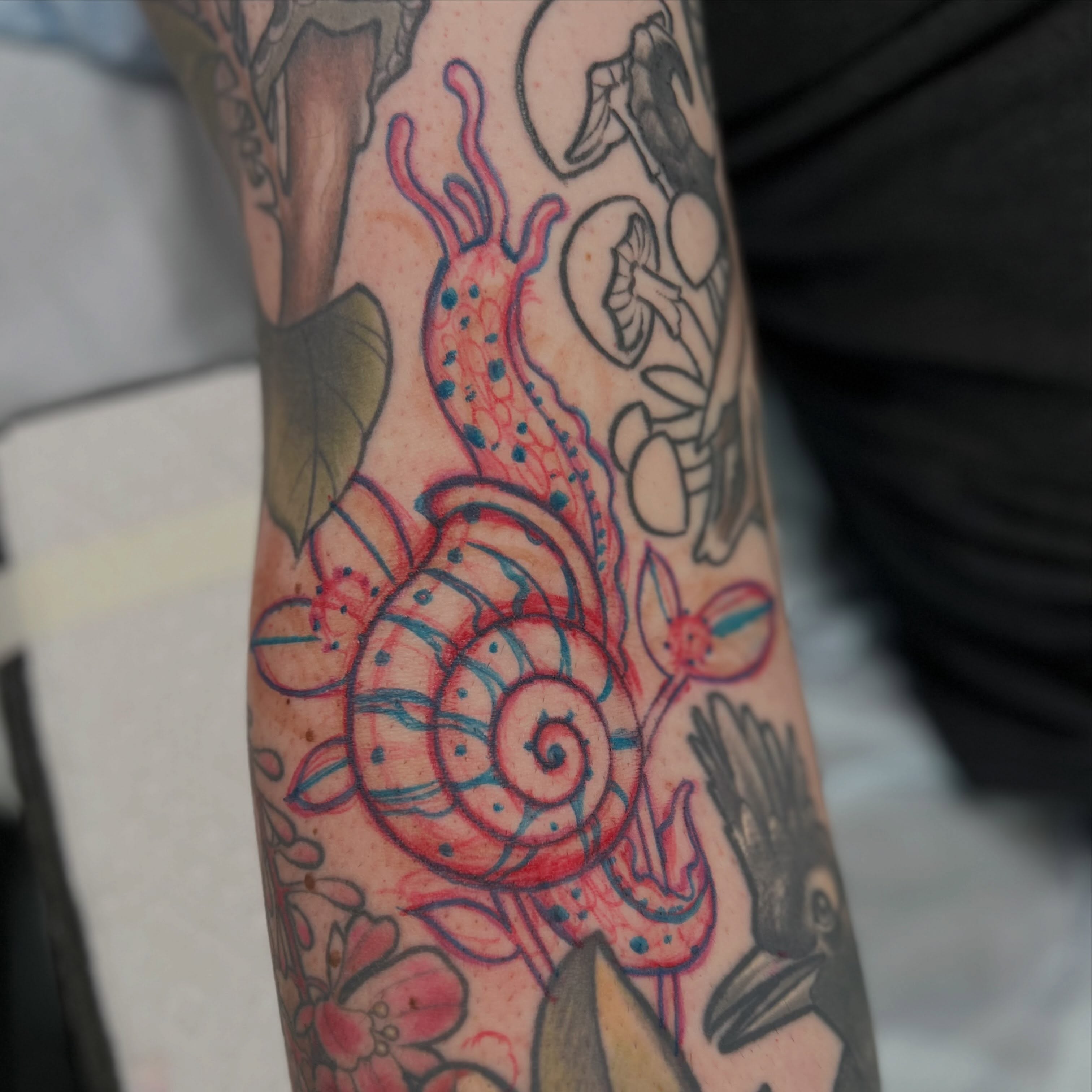 Snail and floral new school tattoo on the forearm by Kyle Olson, Salt Lake City, Utah