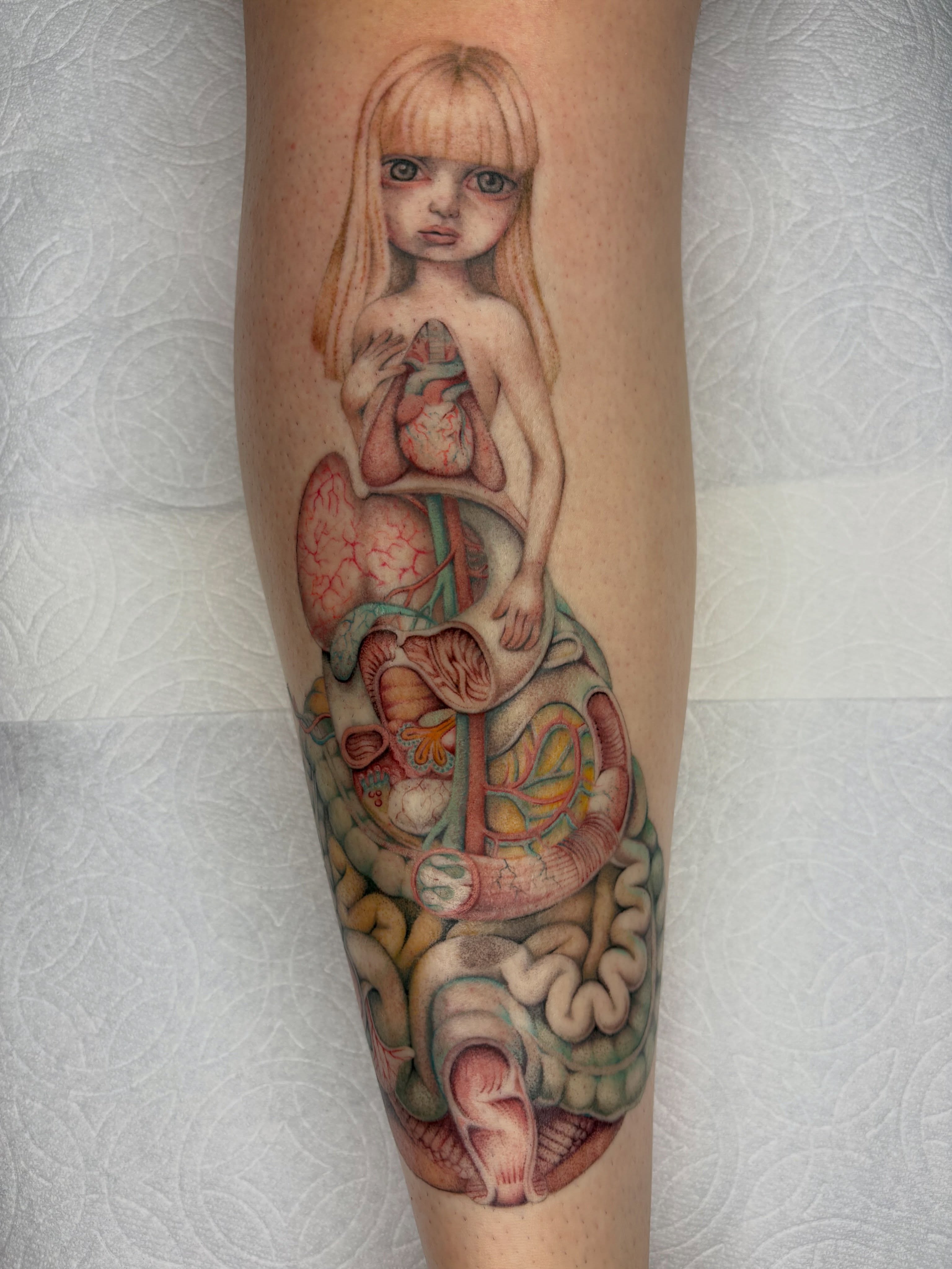 Anatomical heart and girl realism tattoo on the forearm by Nori