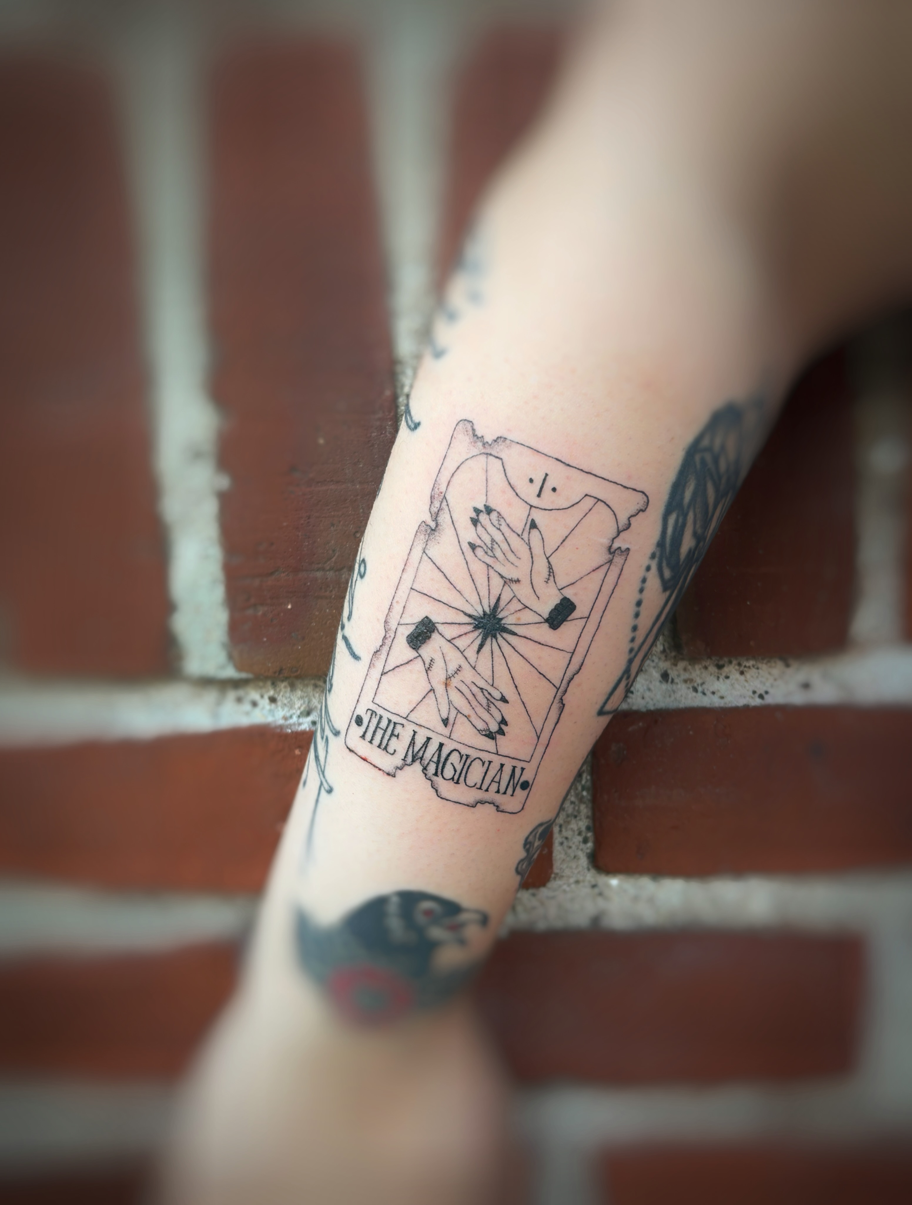 The magician tarot card black and grey tattoo on the forearm by Holly