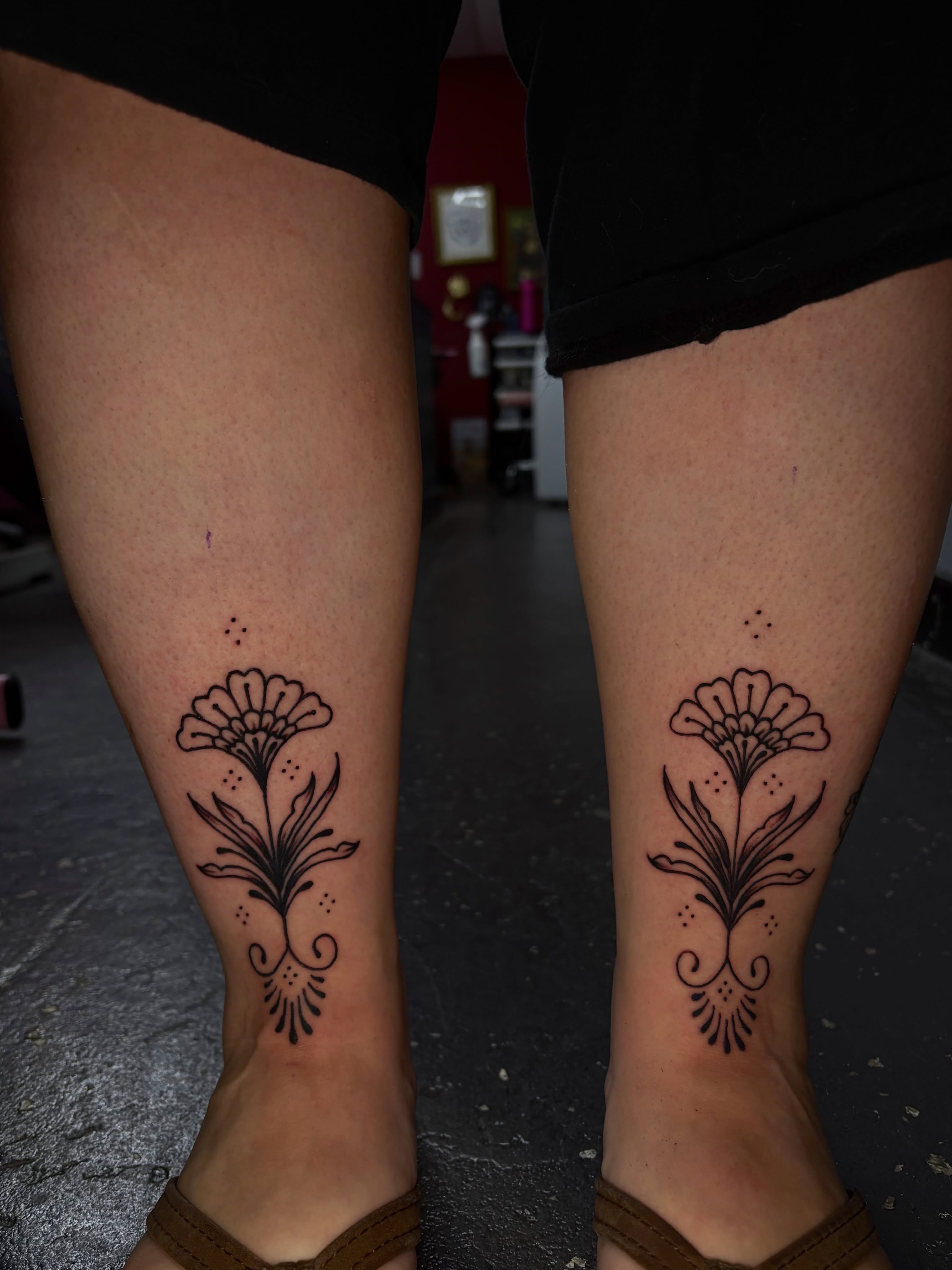 Floral design black and grey tattoo on the calf by Jenna Clayton